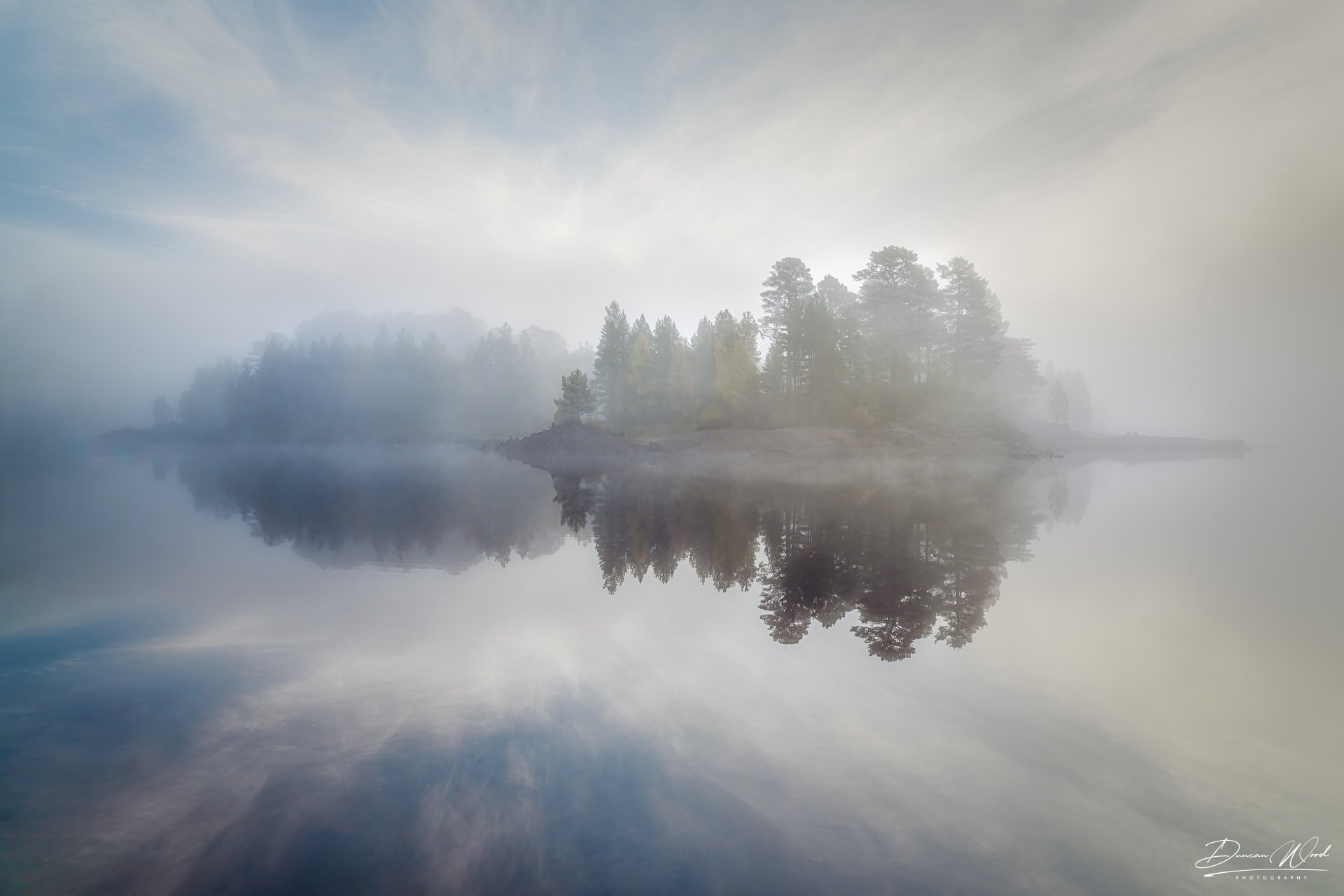 Island reflection in loch, photographed by Duncan Wood in Scotland. Scottish landscape photography.