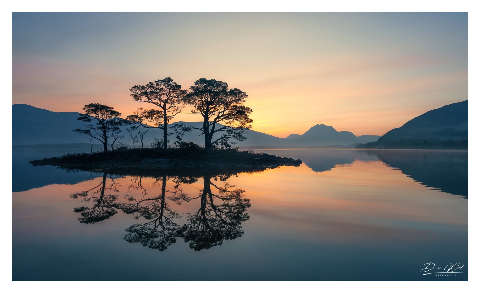 Sunrise reflection at Loch Maree, photographed by Duncan Wood in Scotland. Scottish nature photography.