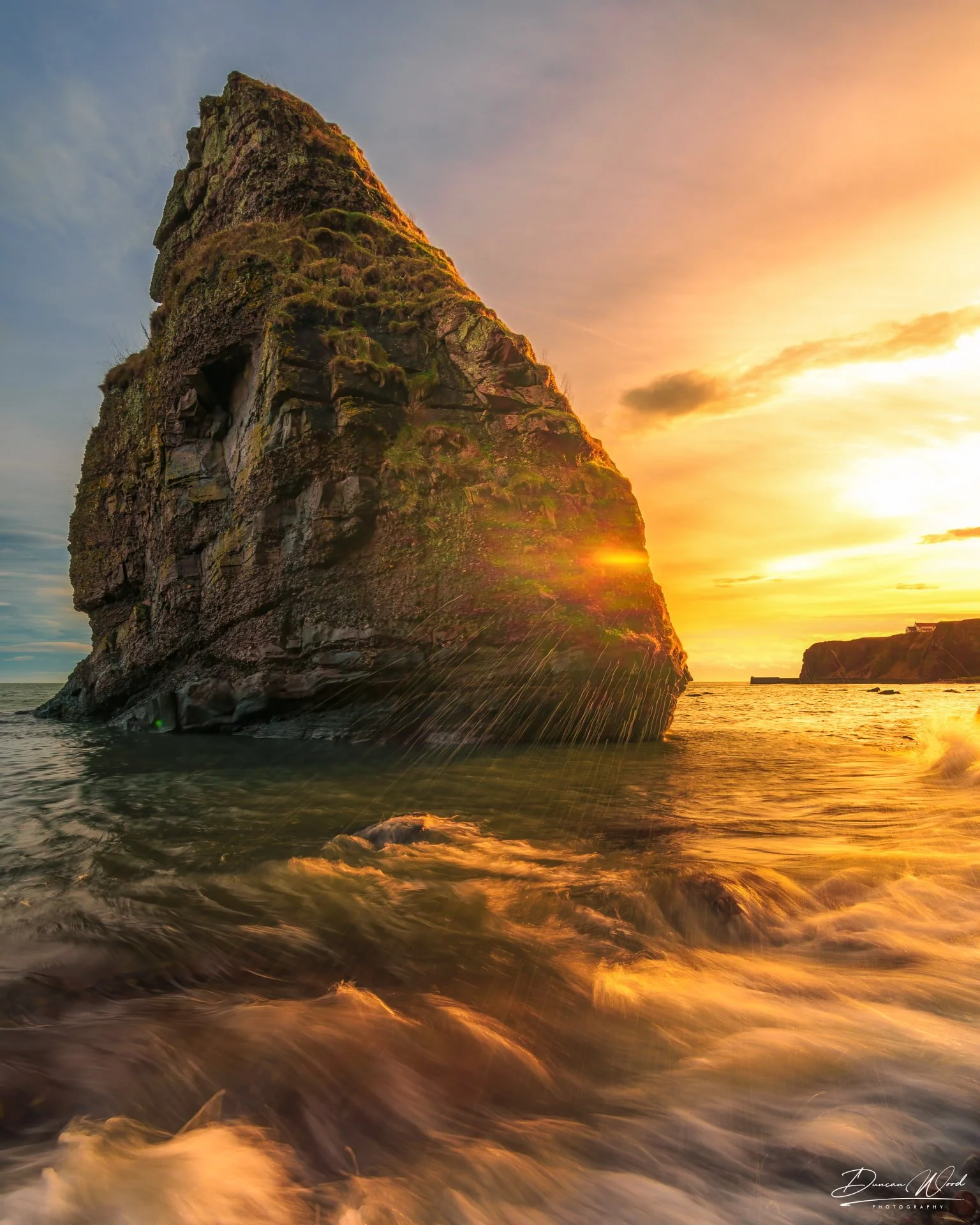 Sea stack at Auchmithie Bay, Scotland at sunset. Photography by Duncan Wood.