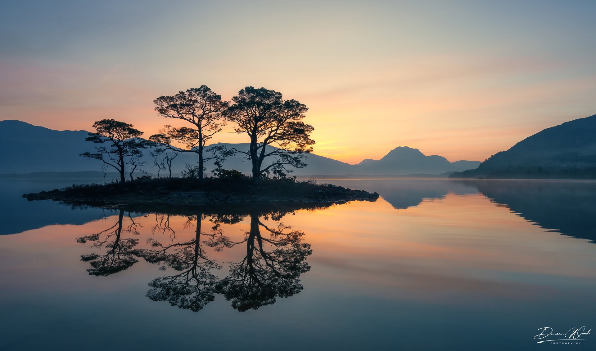 Sunrise reflection at Loch Maree, photographed by Duncan Wood in Scotland. Scottish nature photography.
