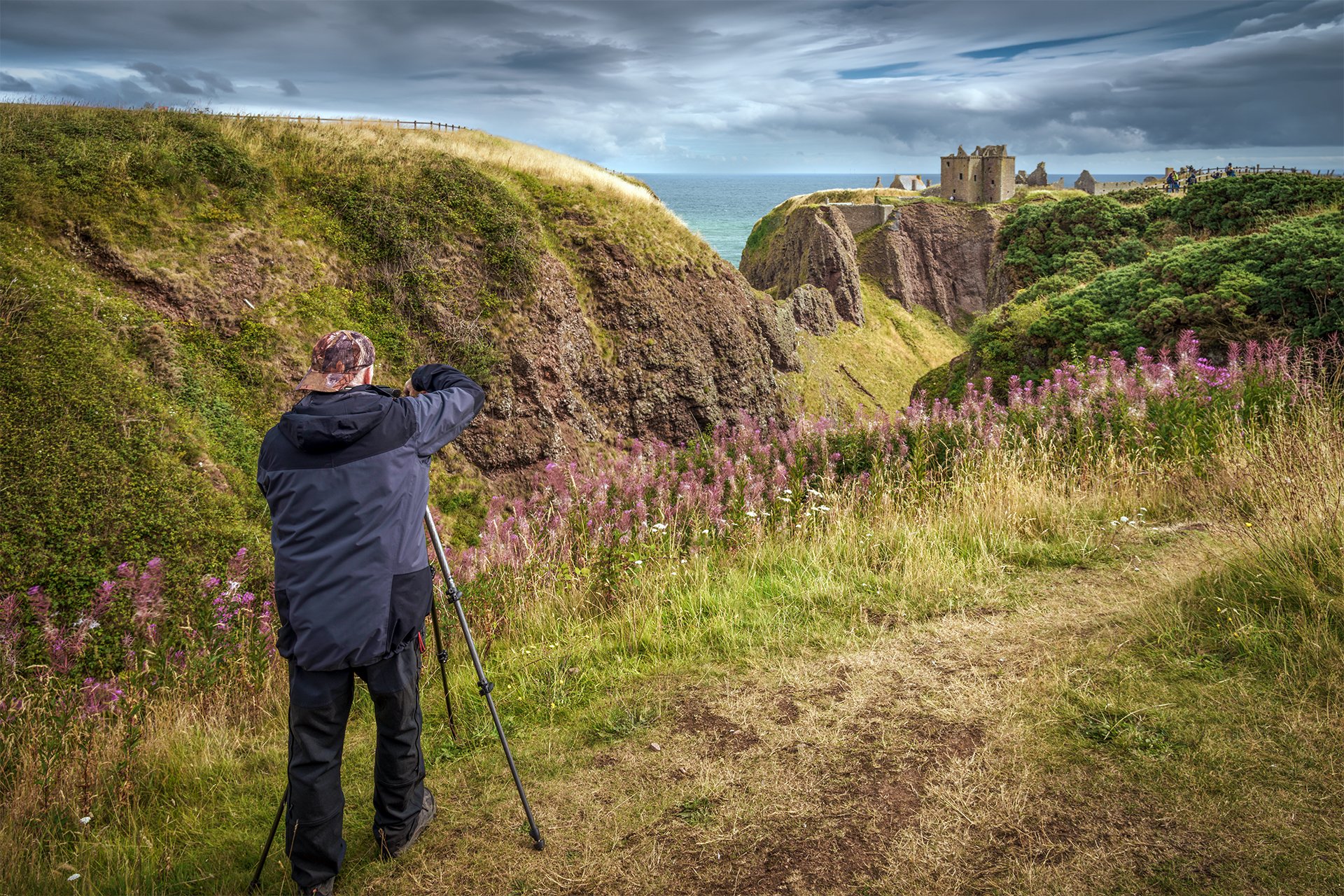 Participant photographing Dunnottar Castle on a beginner photography workshop in Scotland