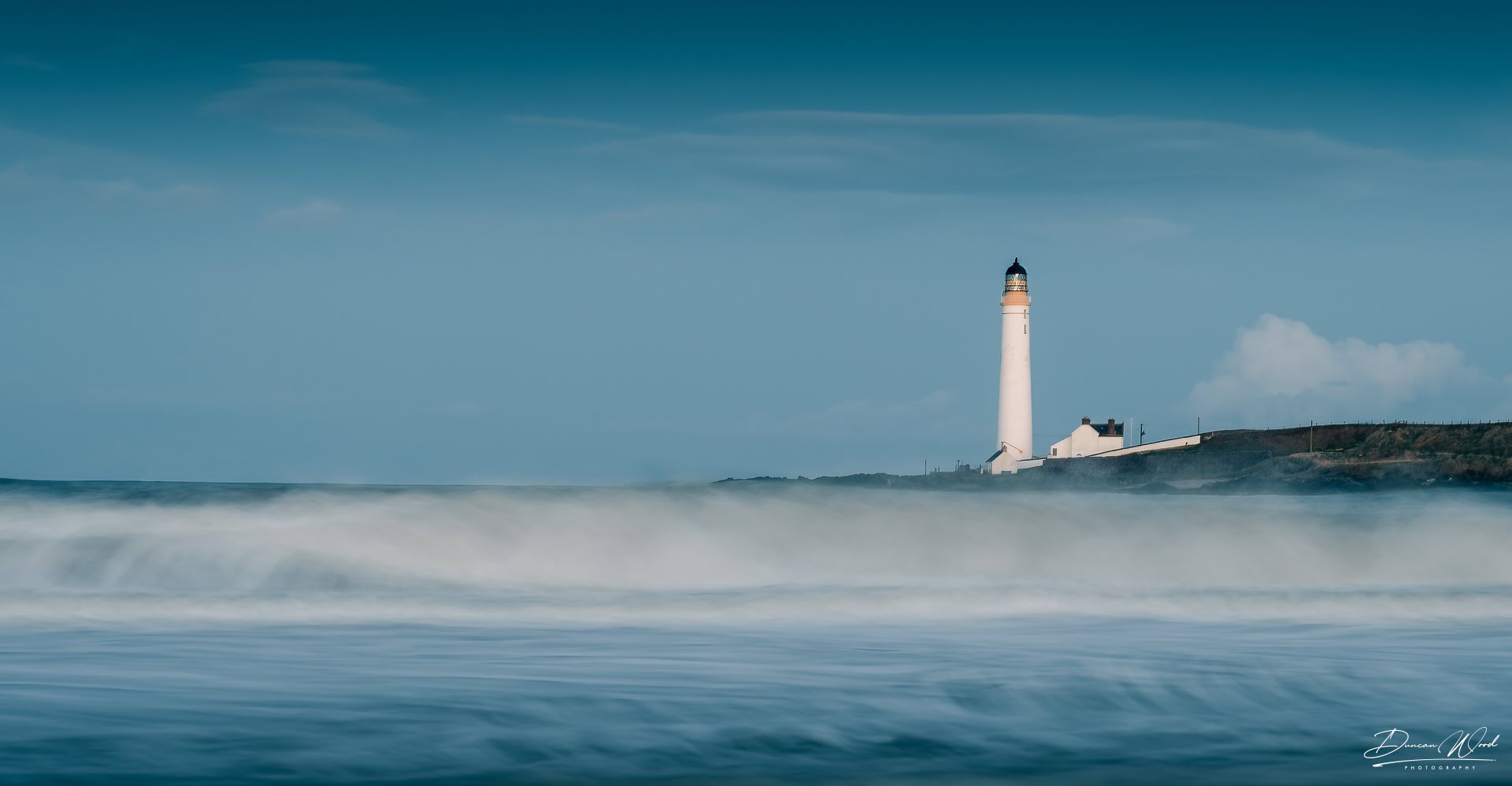 Scottish coastal seascape with lighthouse, tide movement and soft blue light