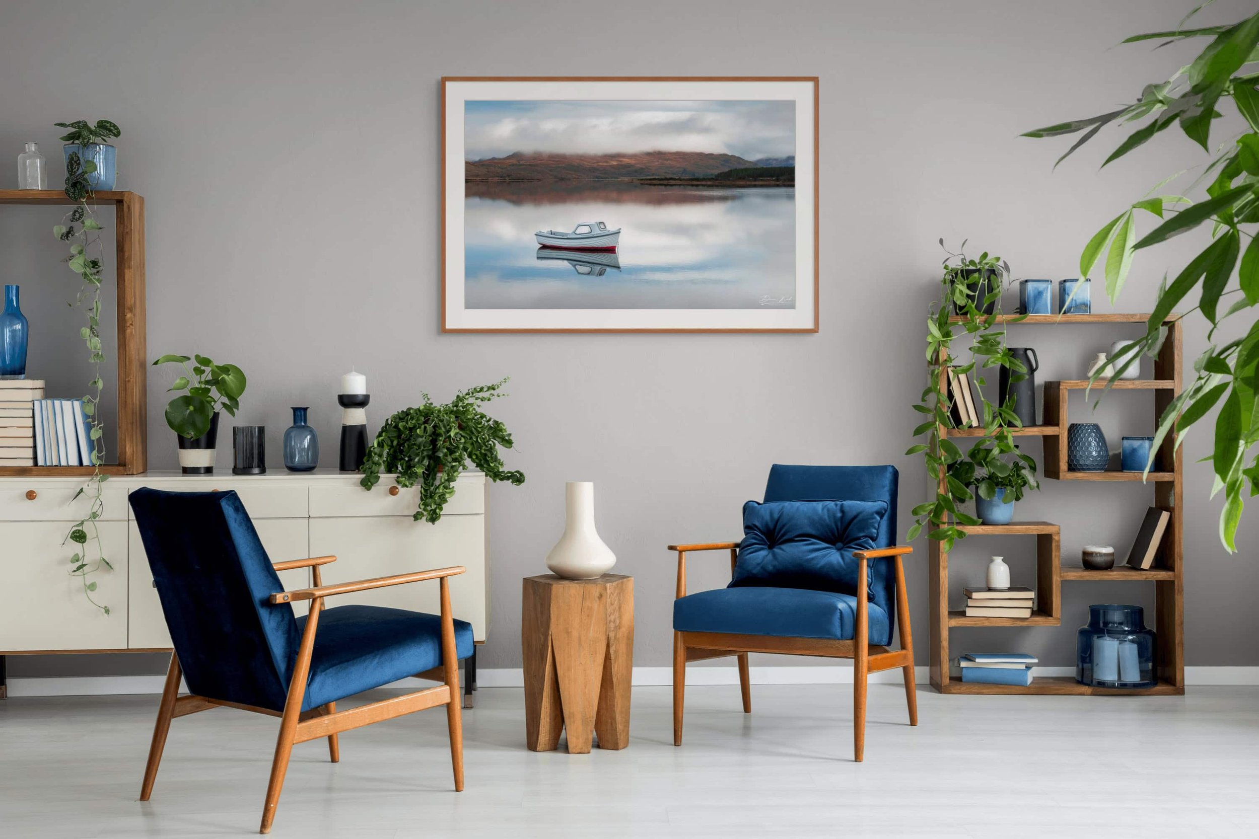 Framed print of Anchored Silence by Duncan Wood displayed on a wall. Scottish nature photography featuring a tranquil loch scene.