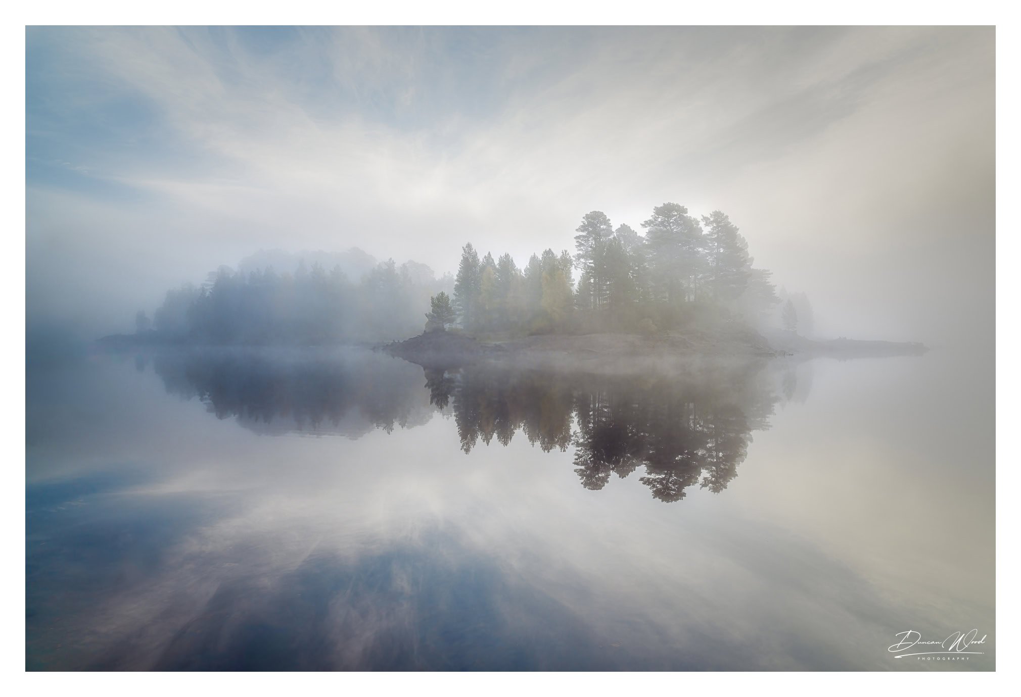 Island reflection in loch, photographed by Duncan Wood in Scotland. Scottish landscape photography.