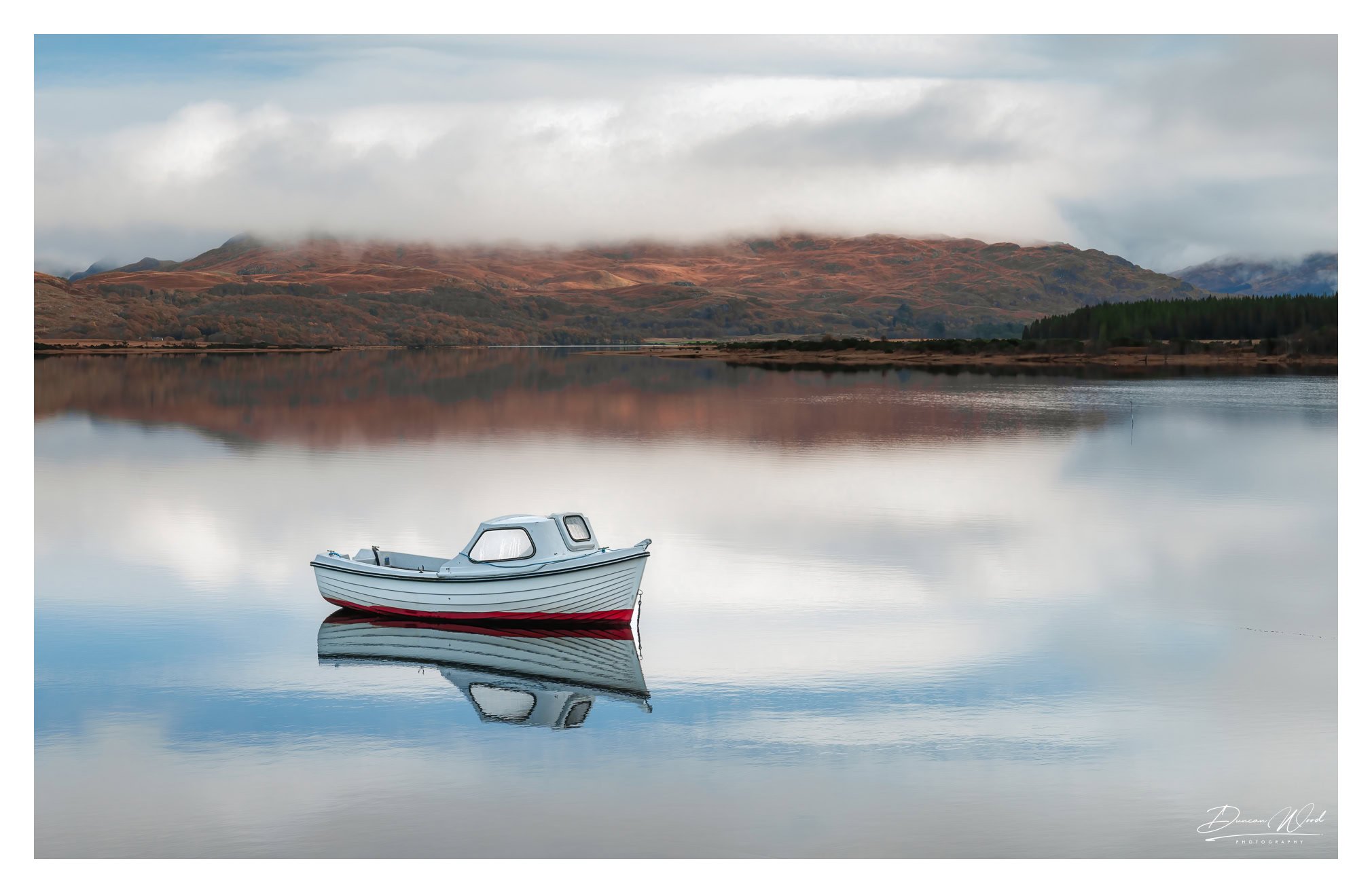 Fishing boat on still loch, photographed by Duncan Wood in Scotland. Scottish landscape photography.
