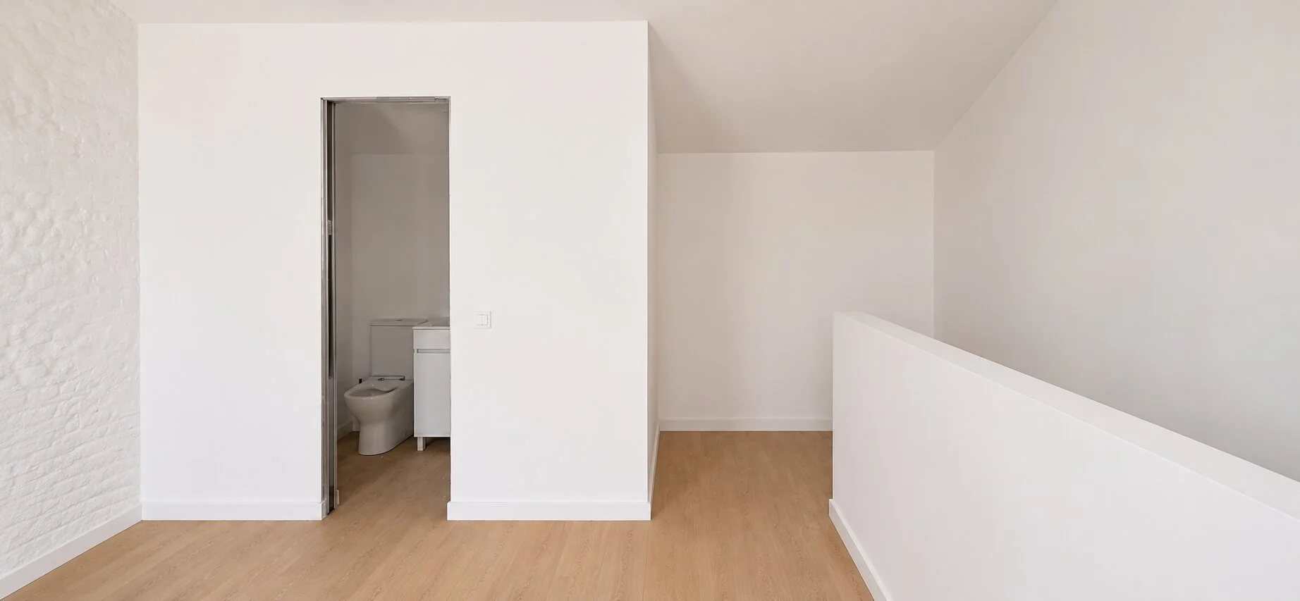 Simple white bedroom interior with restored traditional wall texture in Cebolais de Cima