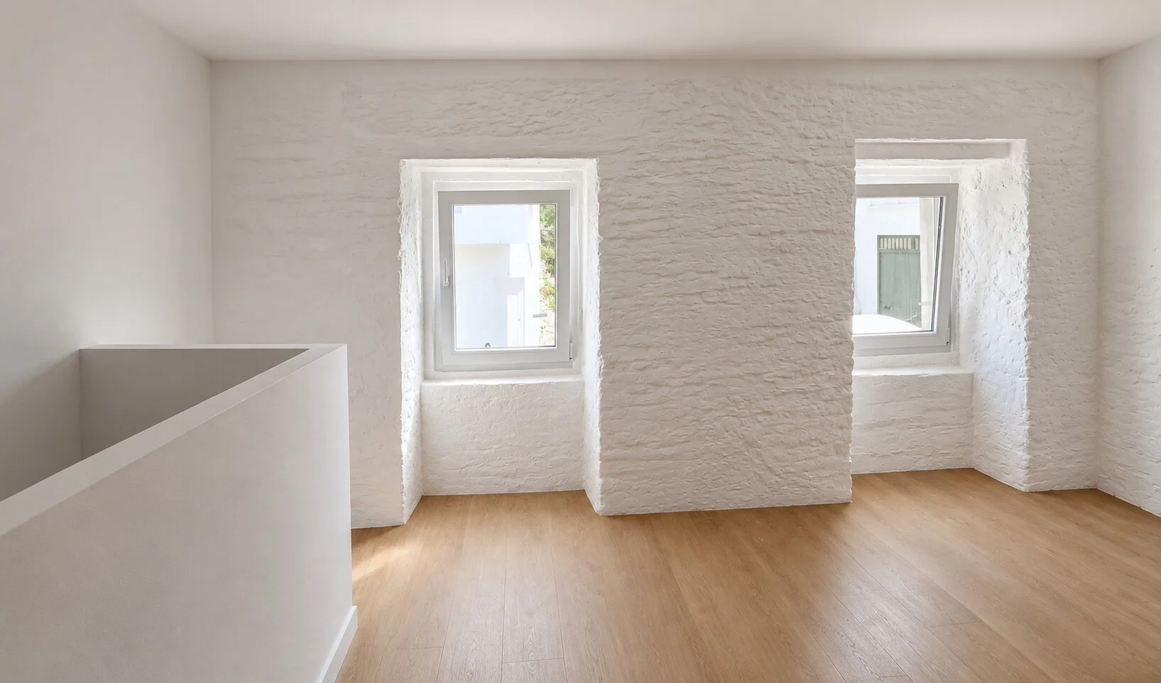 Renovated interior of Casinha dos Cebolais with white walls, and oak flooring