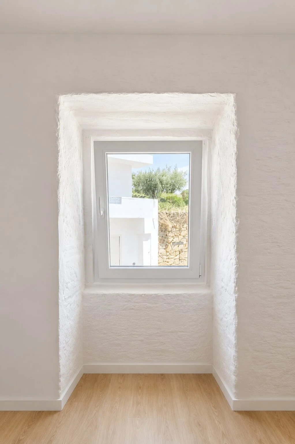 Renovated bedroom interior with white walls, oak flooring and views