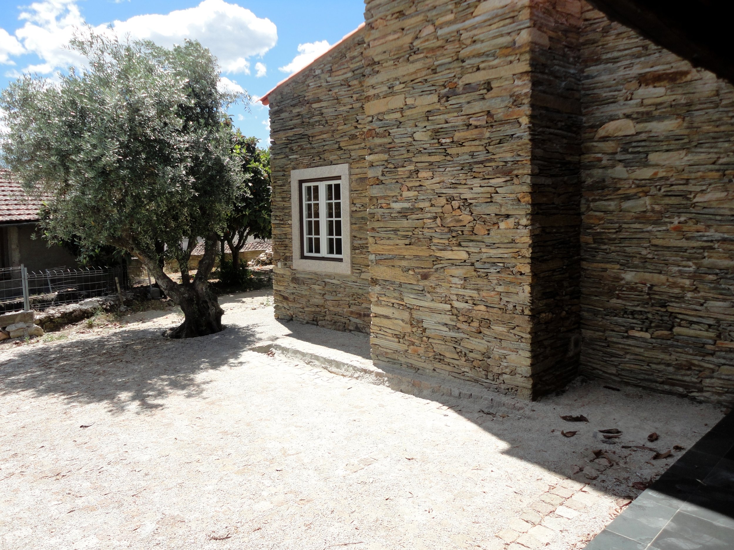 Exterior courtyard of a renovated traditional stone house in Cebolais de Cim