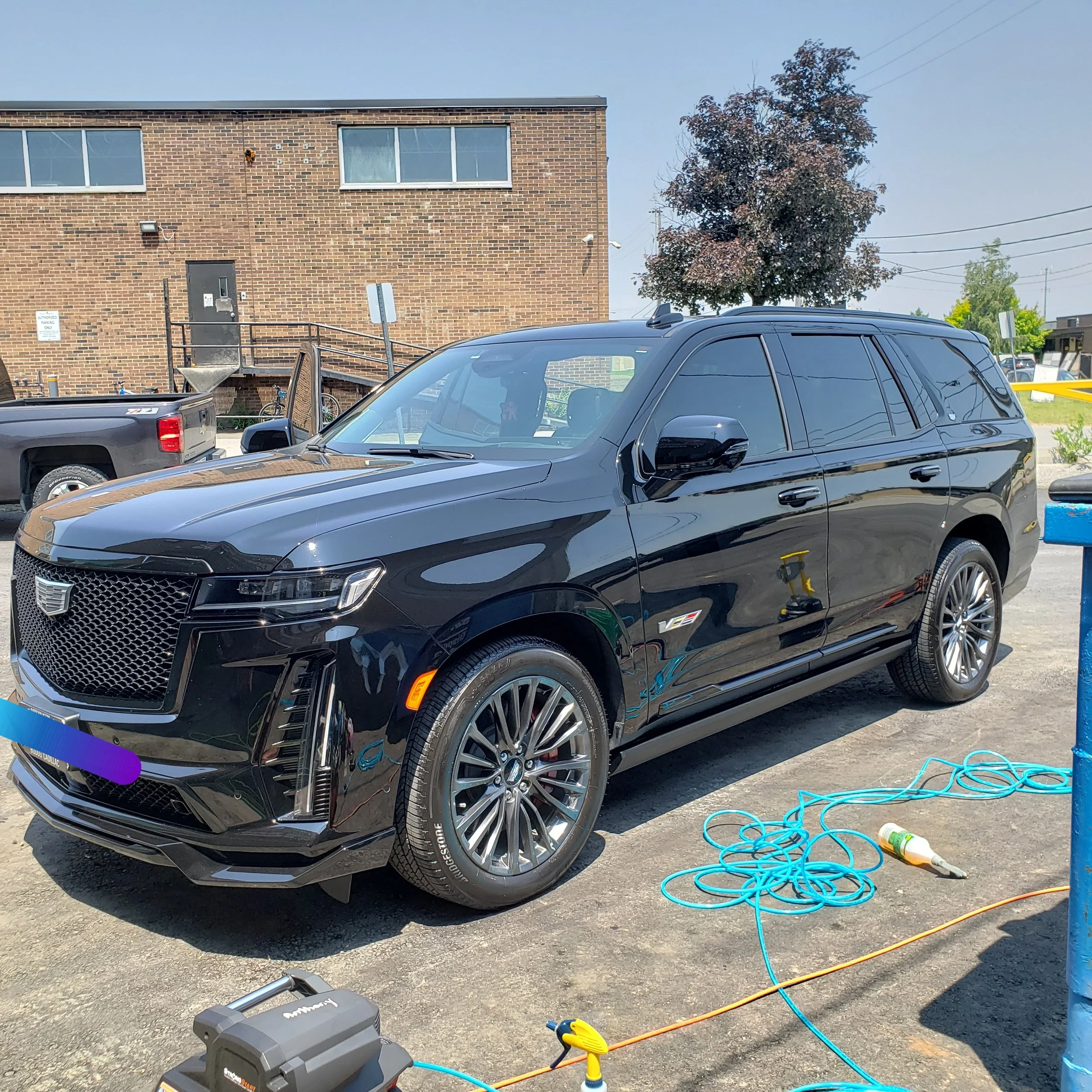 Luxury Cadillac Escalade receiving full interior and exterior deep clean on work site, this includes steam cleaning, carpet shampoo, leather conditioning and paint sealant application on paint