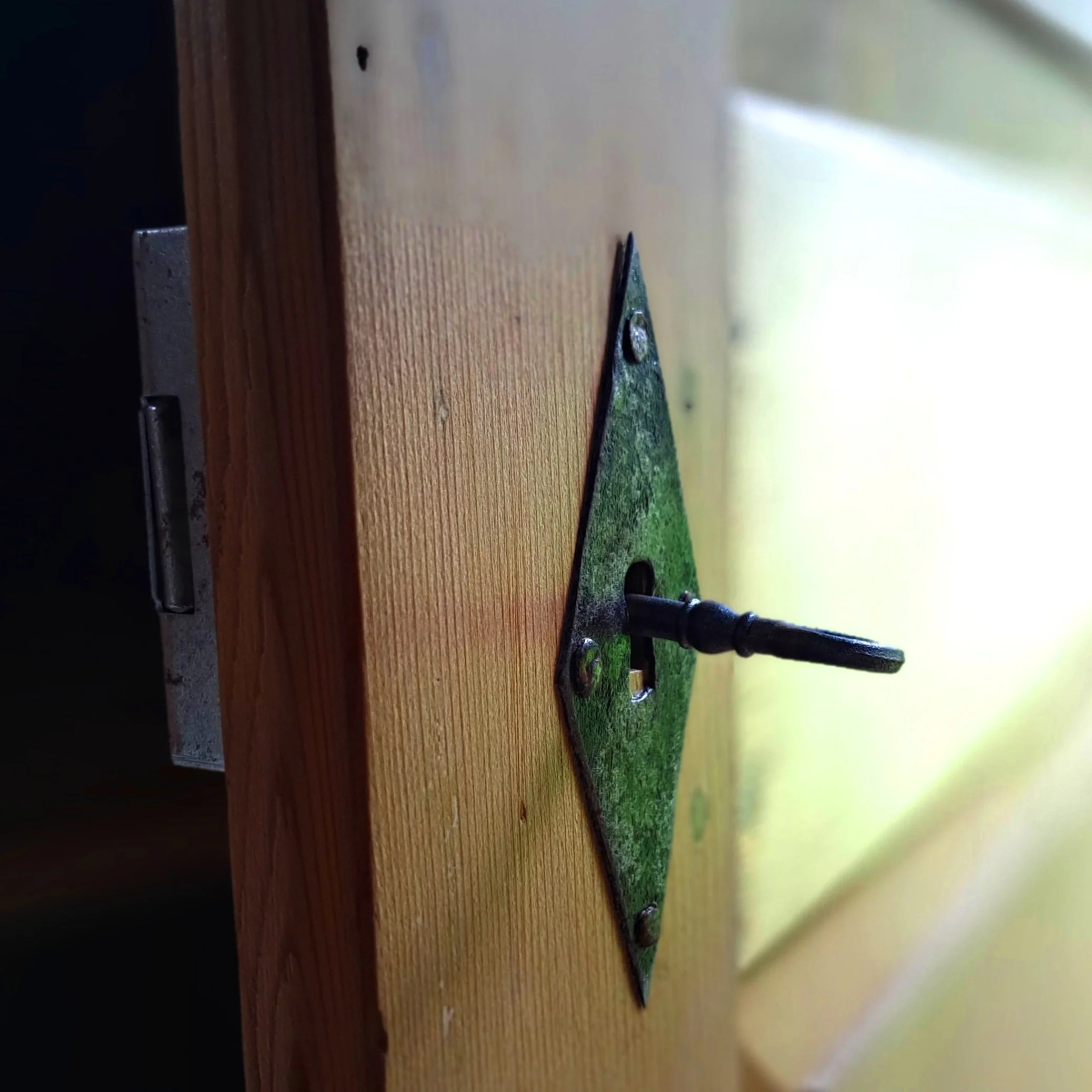 Nahaufnahme eines alten, rostigen Schlüsselsschlüssels, der in einem Schloss steckt