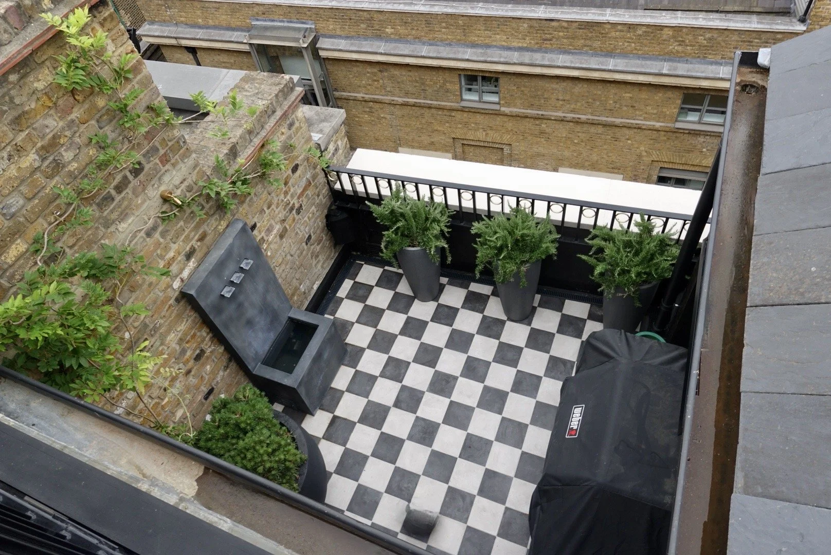 Penthouse roof terrace with planters and seating overlooking central London