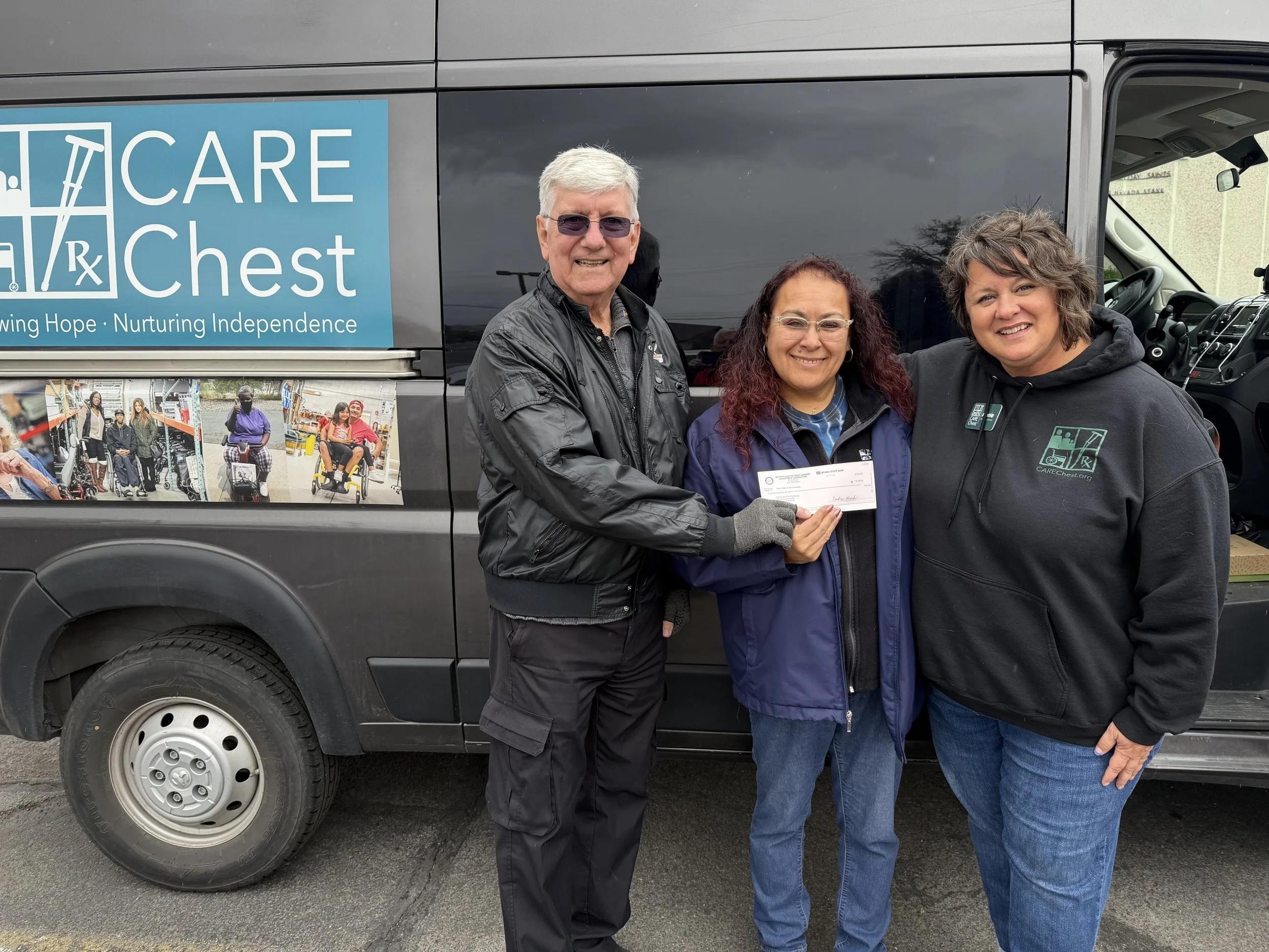 The President of Reno Sunrise Rotary presenting a check to Executive Director, Anne McNulty, and Outreach Coordinator, Celia Hurtado