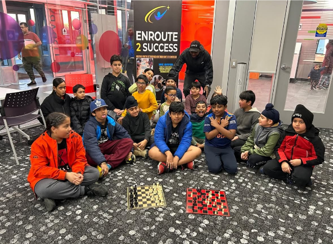 Youth participants posing for photo after a EnRoute 2 Success youth chess lesson.