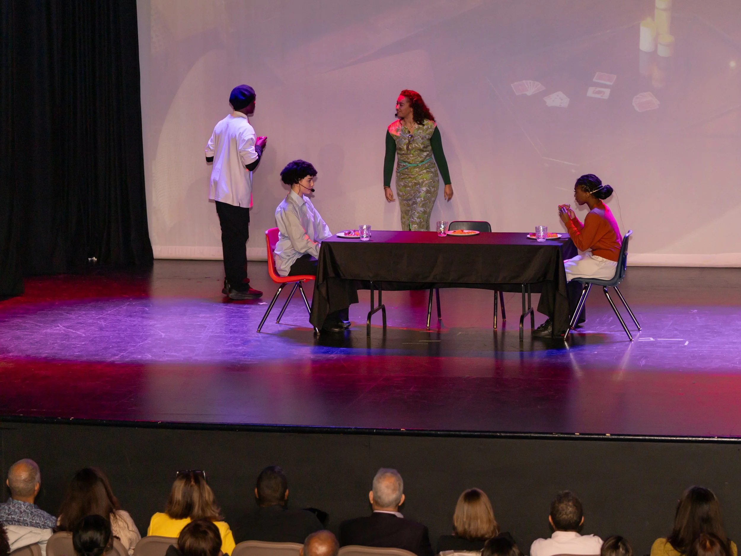 Youth actors performing a dinner table scene during Breaking Barriers: The Story of Gloria Baylis play
