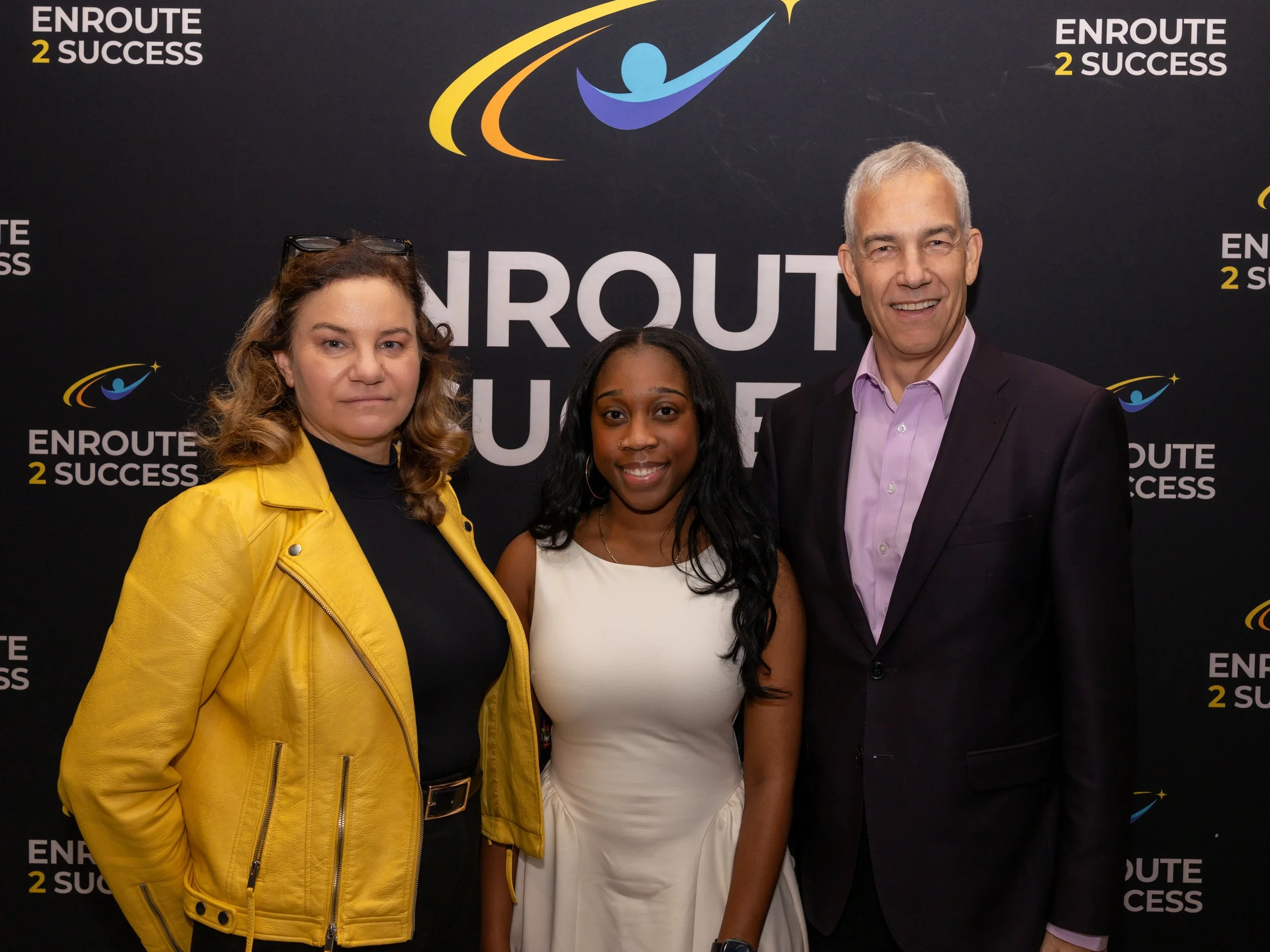 Group photo in front of EnRoute 2 Success backdrop at Breaking Barriers: The Story of Gloria Baylis