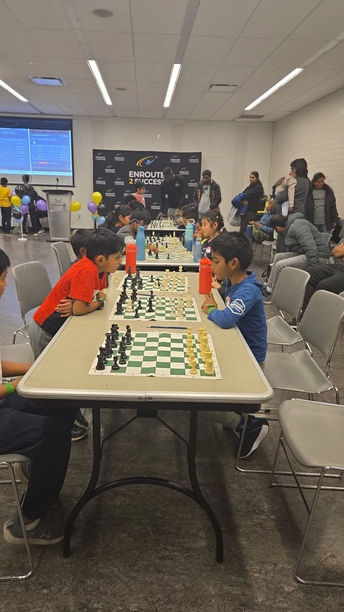 Youth participants concentrating during chess games at an EnRoute 2 Success tournament