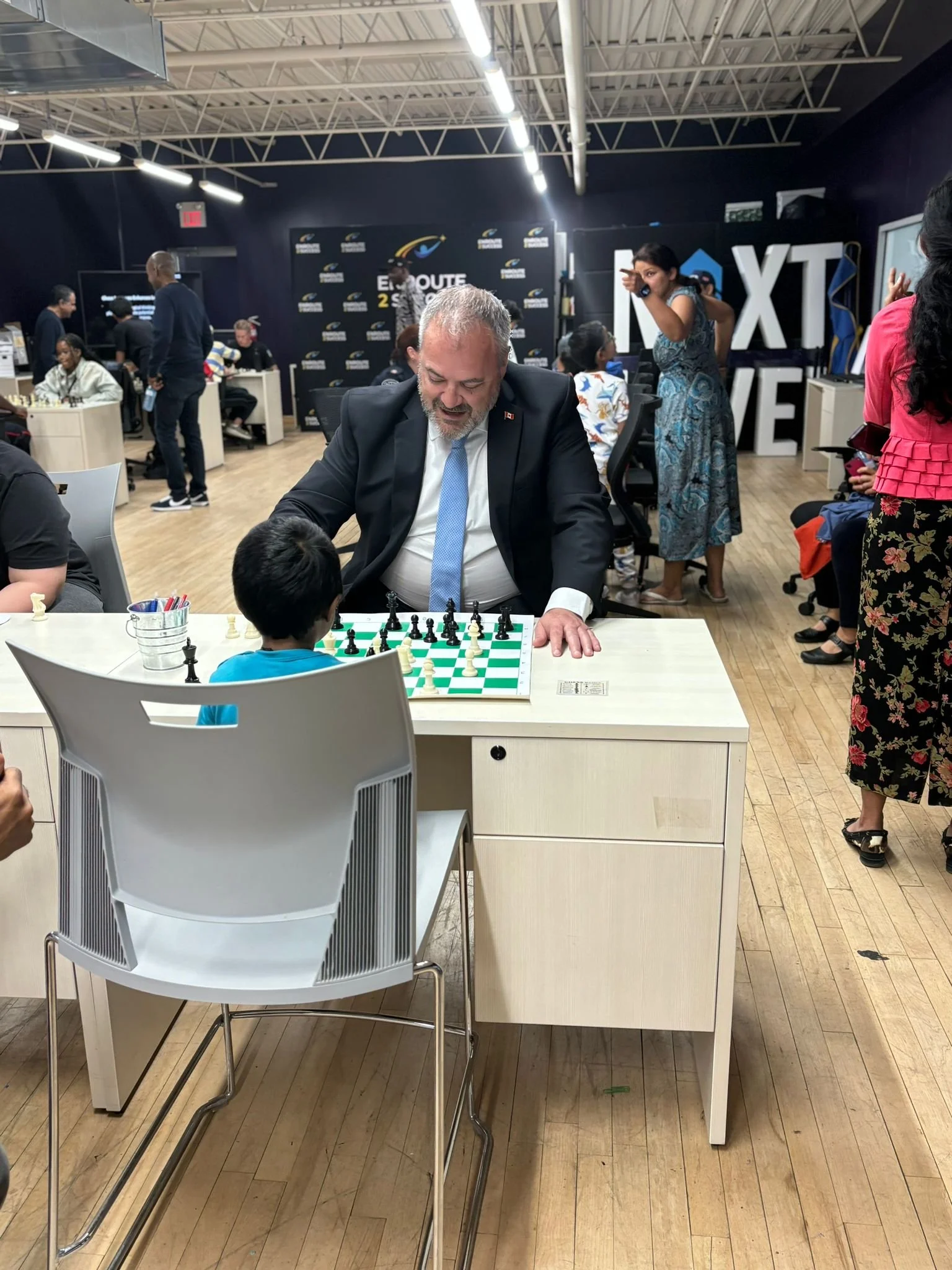 Adult mentor playing chess with a youth participant at an EnRoute 2 Success event