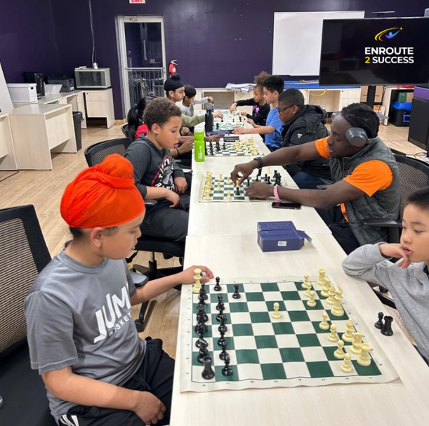 Youth playing chess during an EnRoute 2 Success chess program session