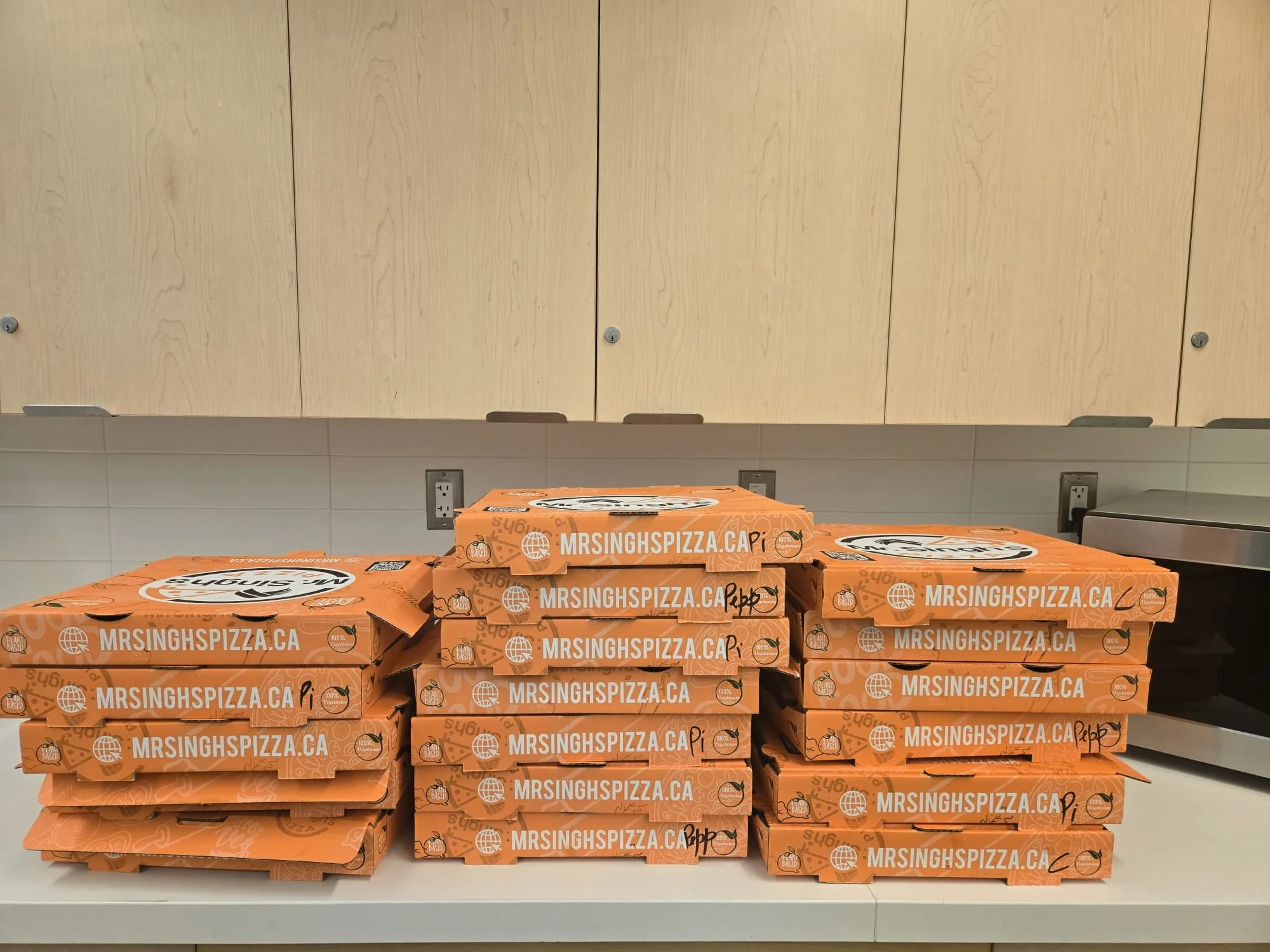 Stack of Mr. Singh’s Pizza boxes prepared for EnRoute 2 Success Chess Fest 2025.