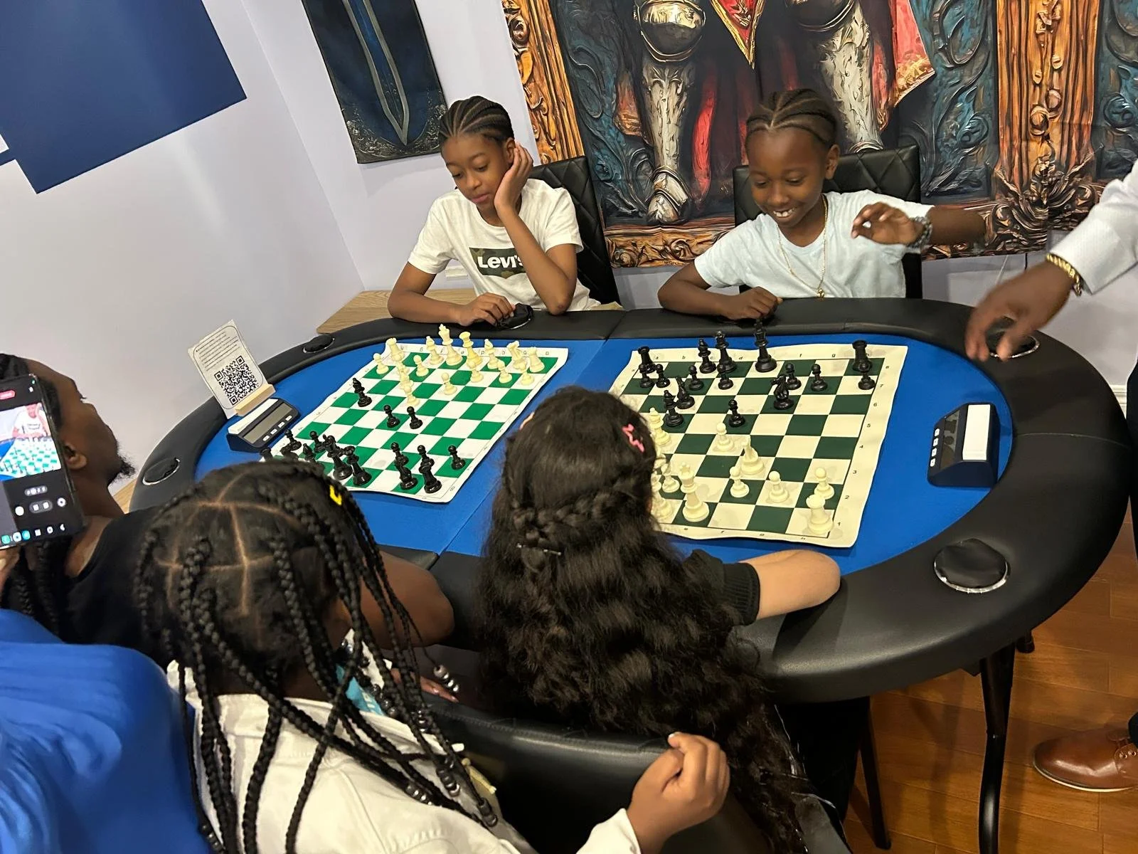 Children playing chess together during an EnRoute 2 Success youth workshop