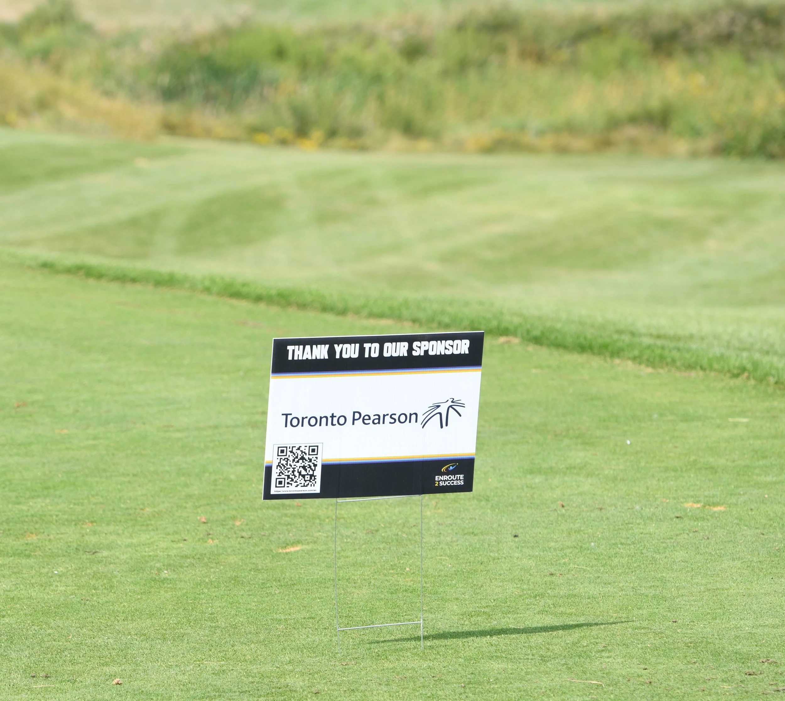 Sponsor sign for Toronto Pearson displayed on a golf course during an Enroute 2 Success golf tournament
