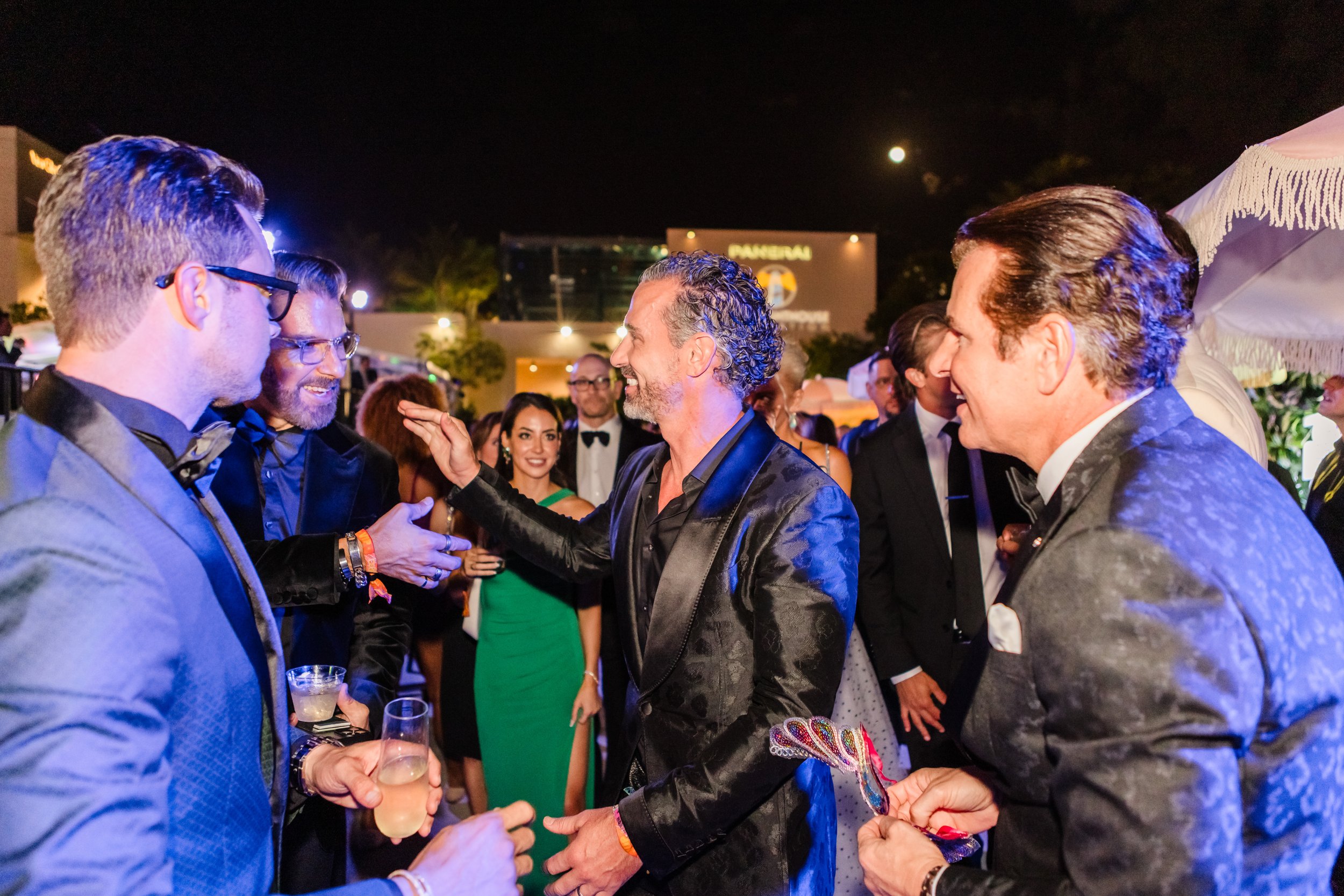 Group of well-dressed men laughing and networking with cocktails at the Little Lighthouse Foundation 2025 Hearts and Stars Gala at Jungle Plaza in the Miami Design District