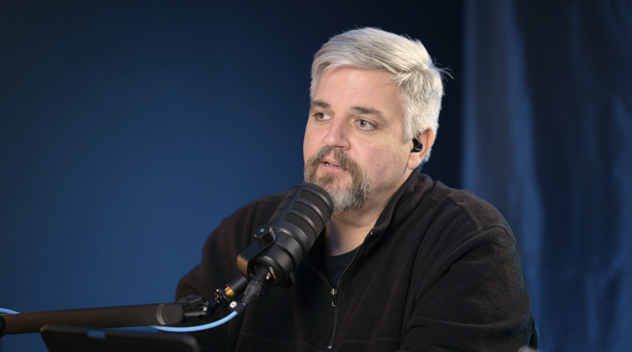 Close-up of a Bible Show host speaking into a studio microphone while recording a video podcast.
