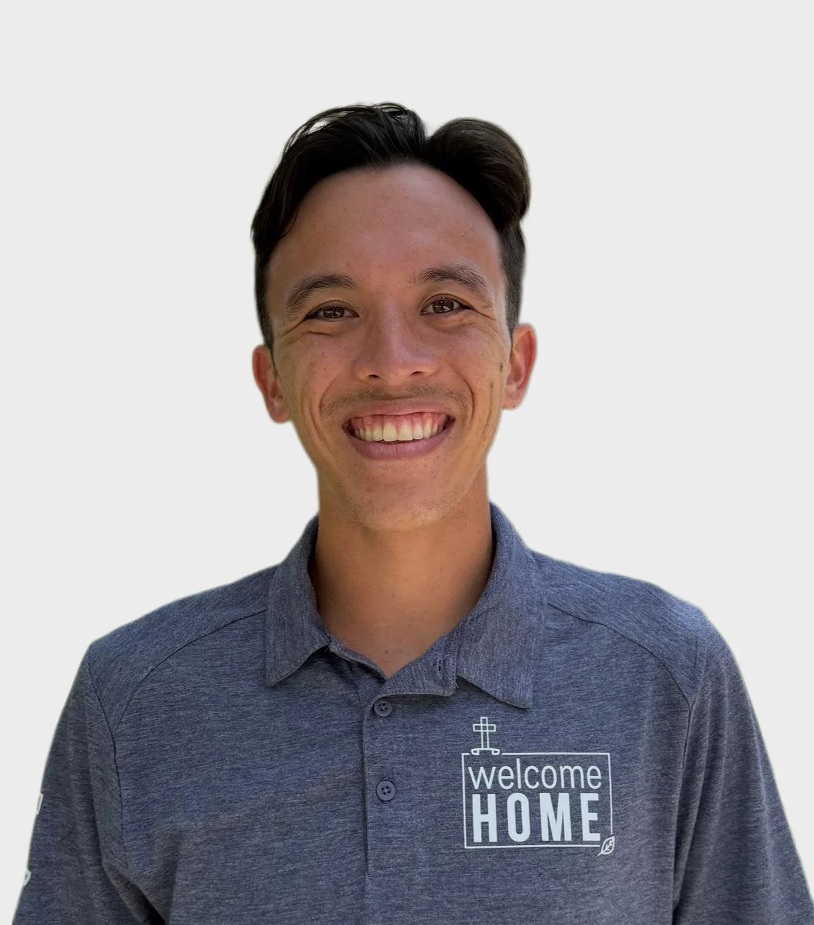 Man smiling at the camera wearing a dark blue polo shirt with tattoos on his arms, set against a plain white background.