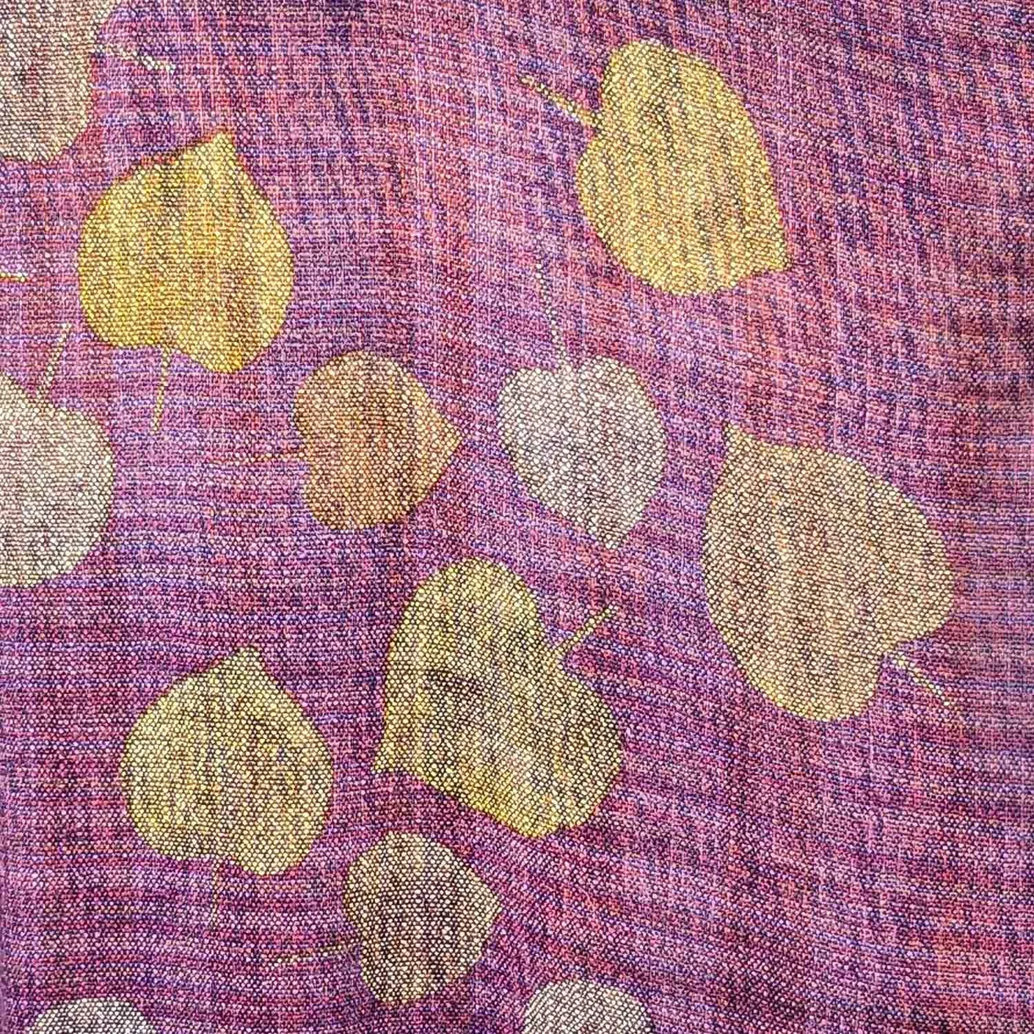 Close-up of colorful handwoven fabric with yellow and beige stencilled leaves on a pink and purple background.
