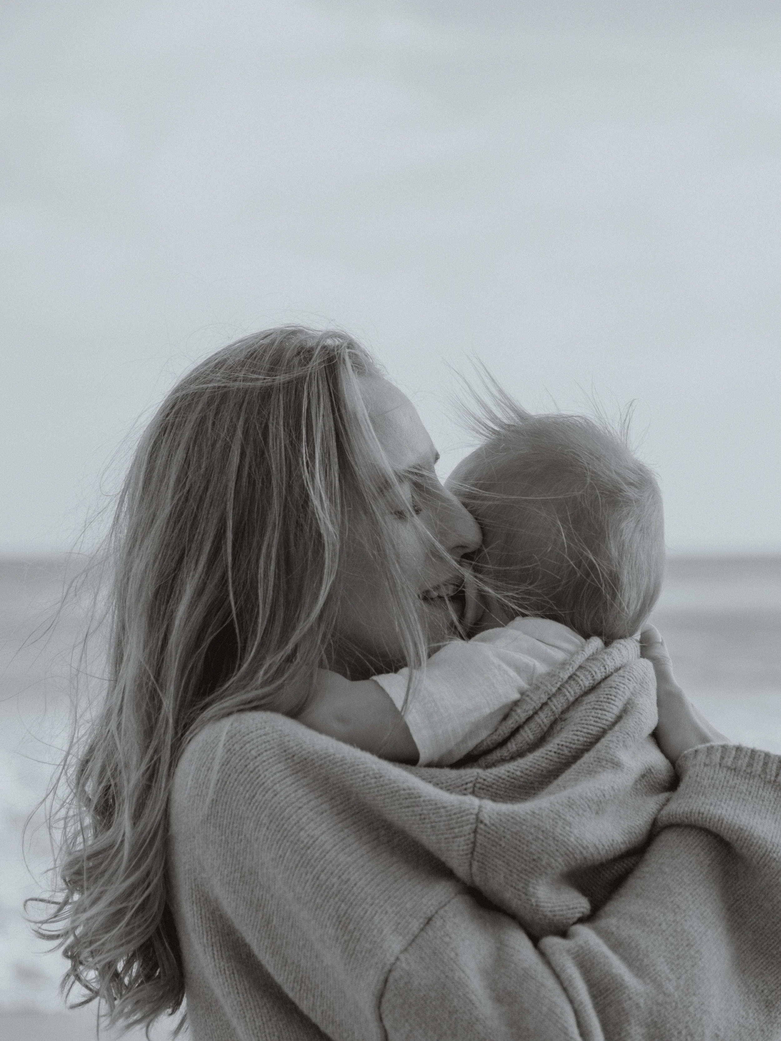 photo in black and white of a mother hugging a baby captured by Emmedelmar in Malibu.