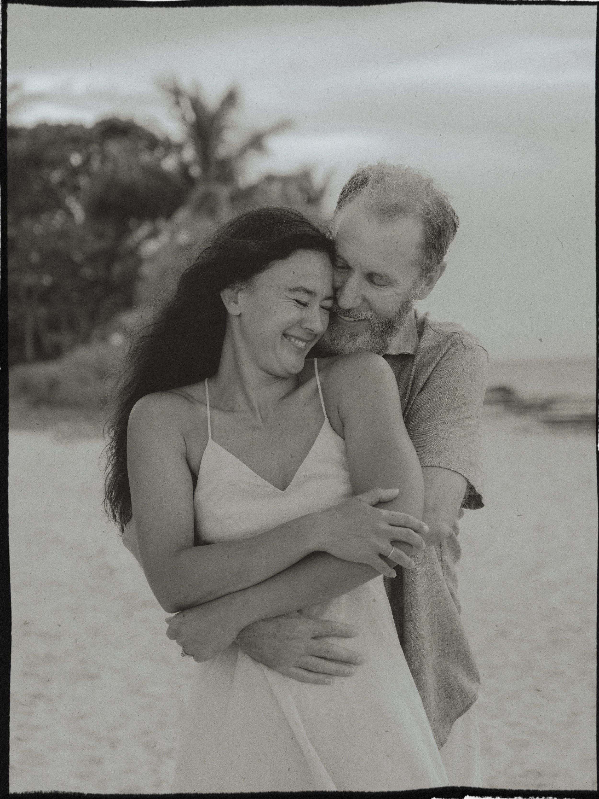 black and white photo of a couple embracing by the beach in Cozumel, captured by Emmedelmar.