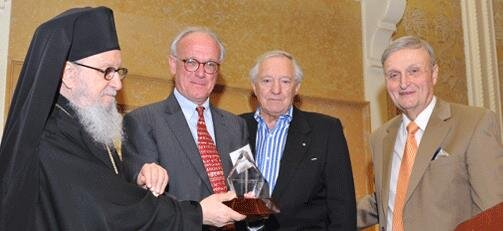 Archbishop Demetrios presents John McKesson Camp II with Archbishop Iakovos Leadership 100 Award for Achievement along with George D. Behrakis, Chairman Emeritus, and Constantine G. Caras