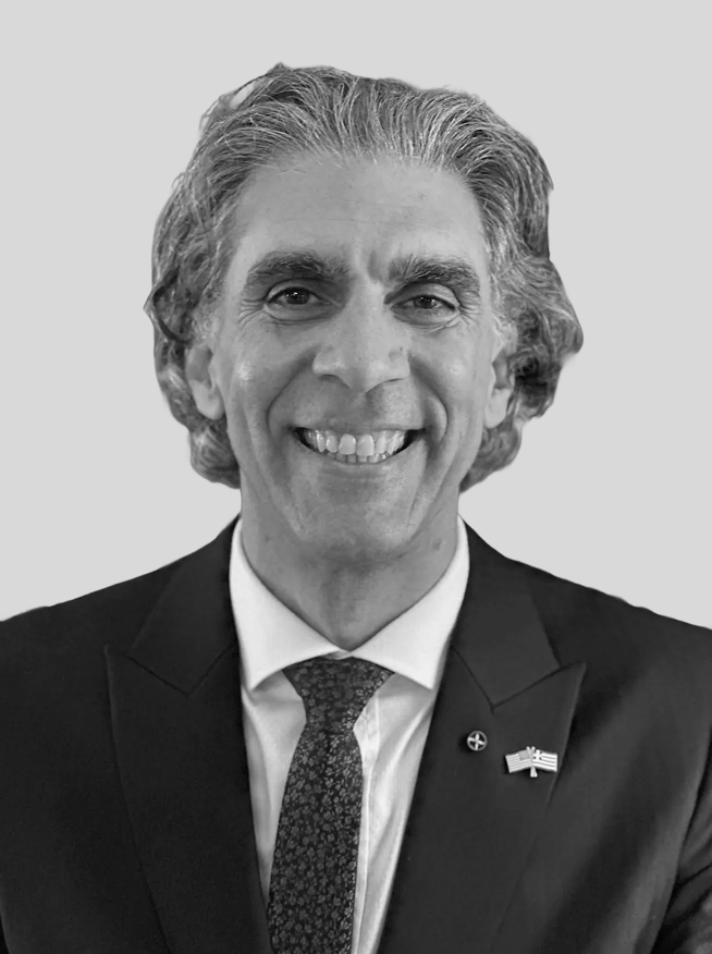 Portrait of a man in a suit and tie, smiling, in black and white.