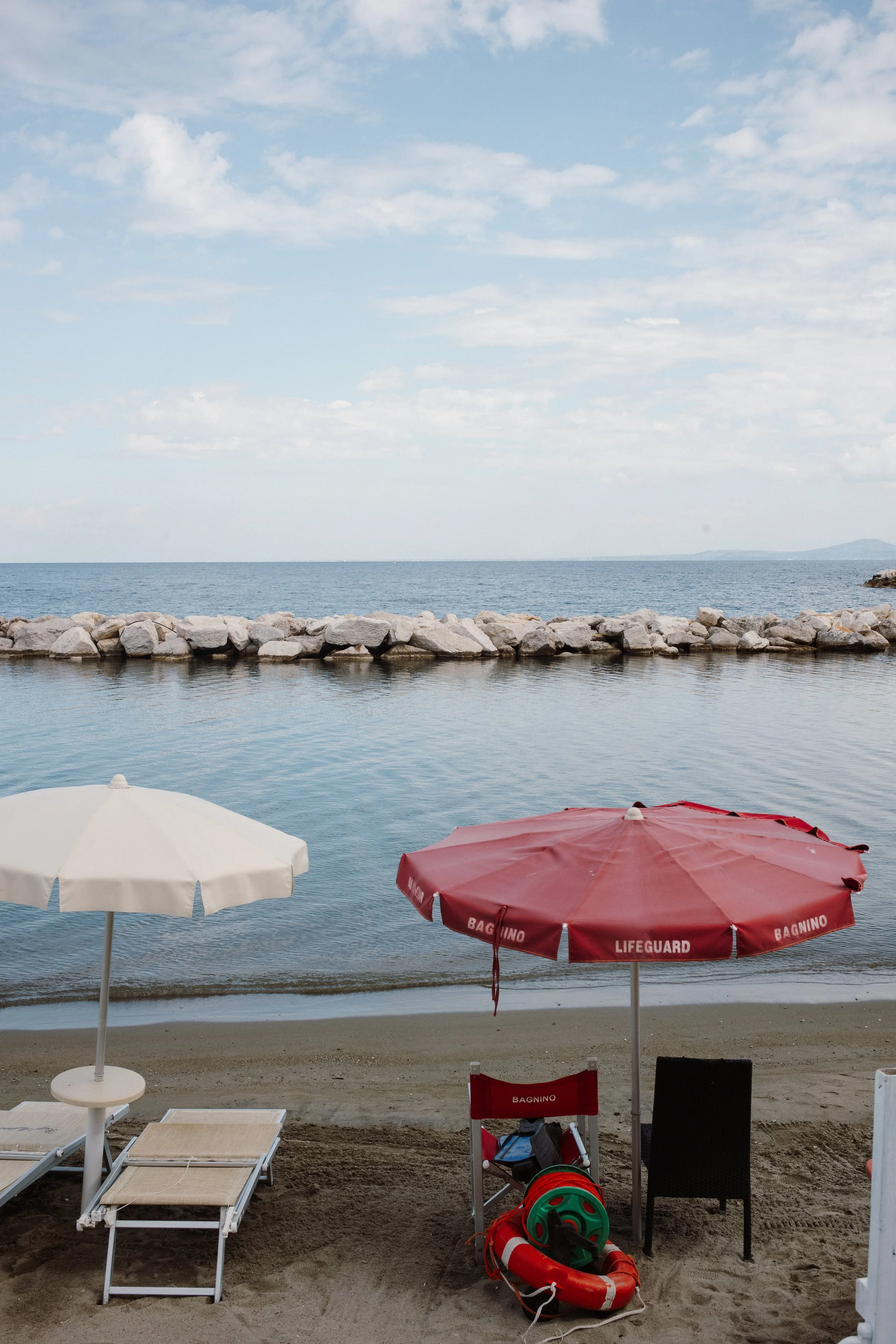 Peaceful beach with umbrellas symbolizing calm and grounding through anxiety therapy in West Los Angeles.