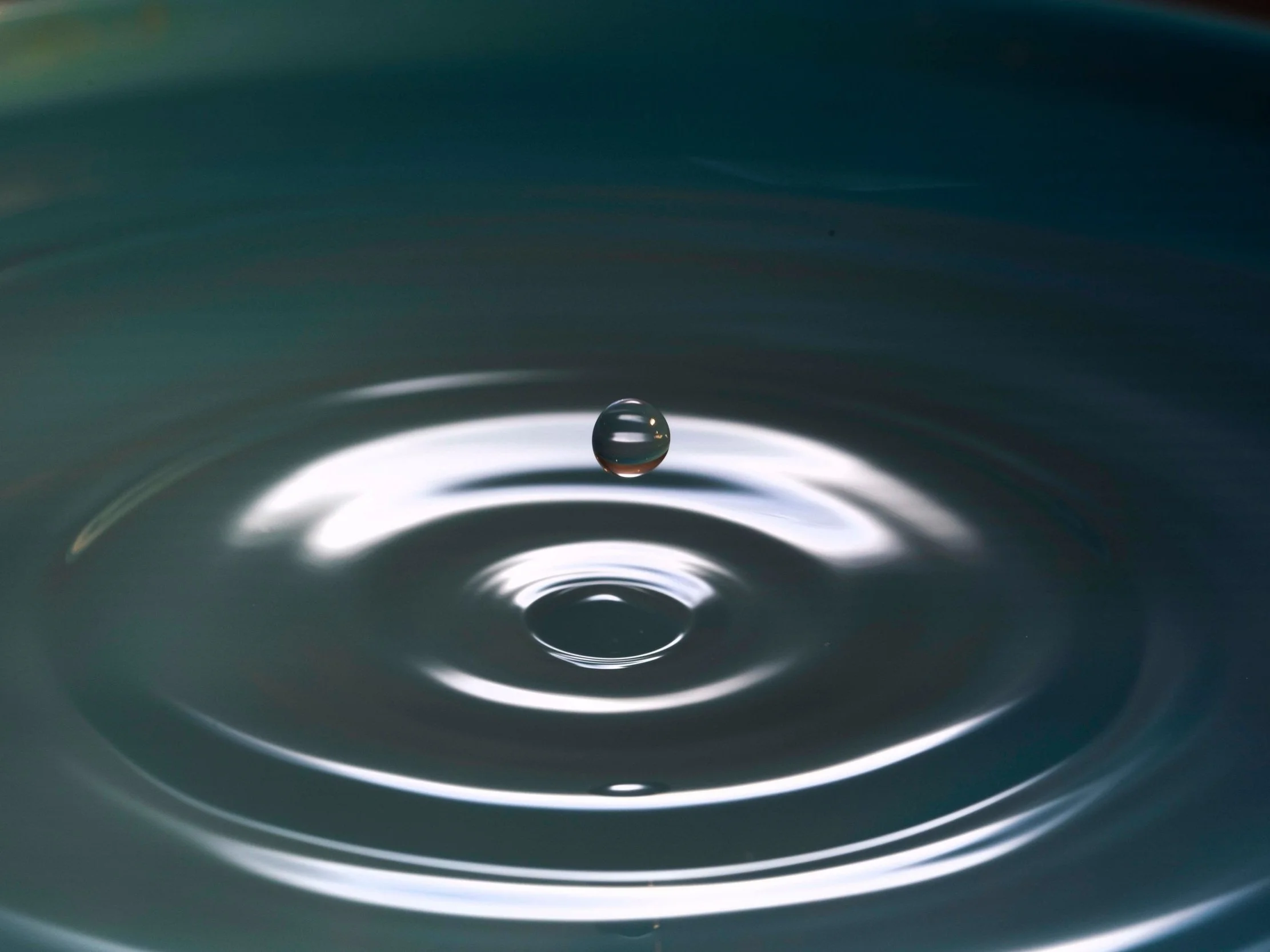 A drop in water rippling out to represent the Sharing Circles aspect of ACER Psychedelic Integration.