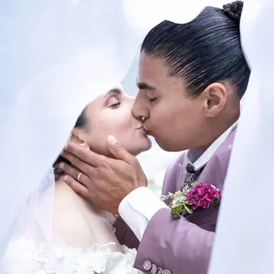 marié qui s'embrasse sous un voile blanc