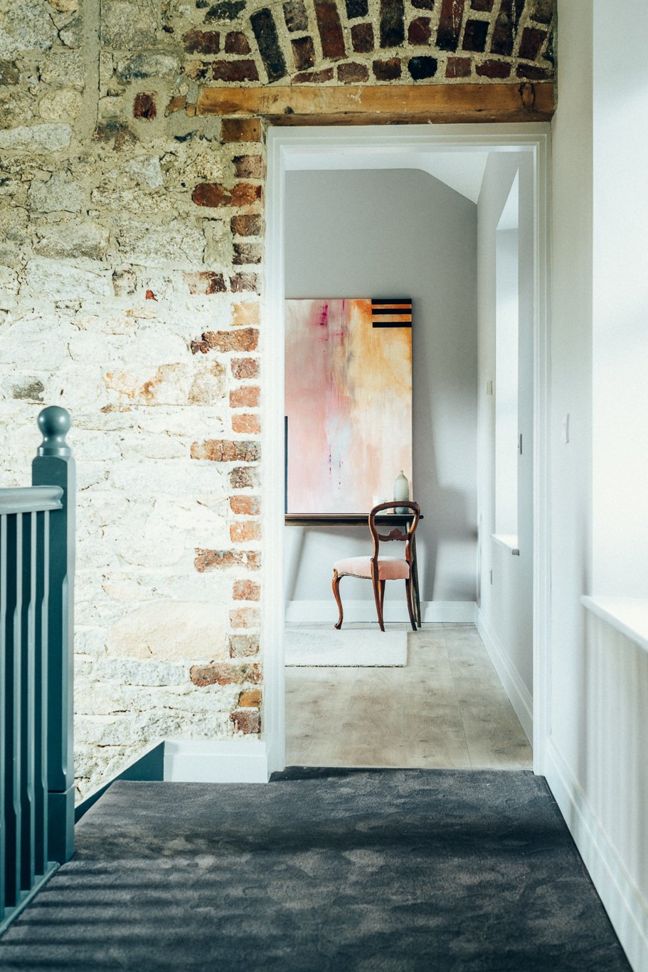 stair landing and brick wall looking into bedroom