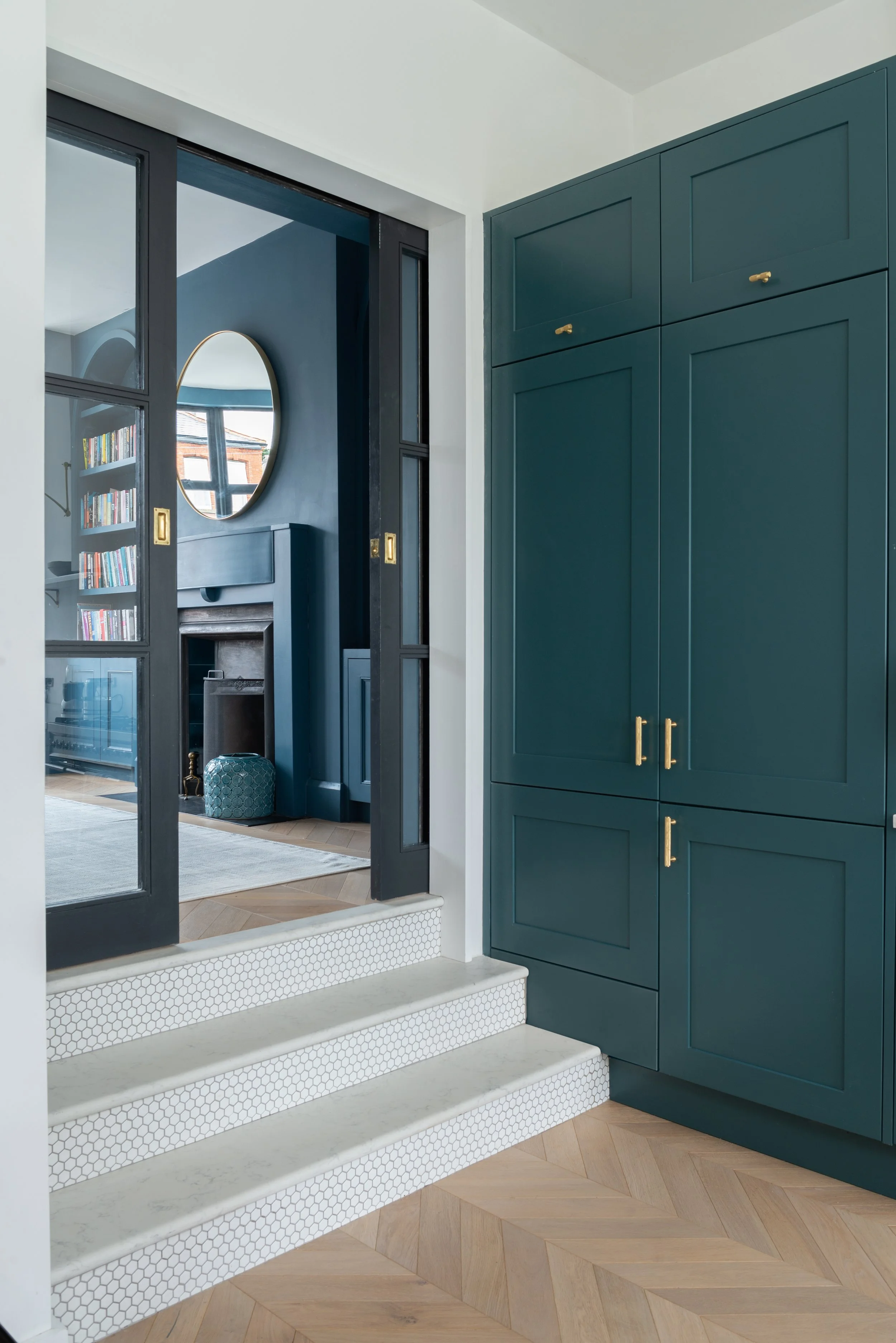 teal cabinetry besides 3 steps into living room space