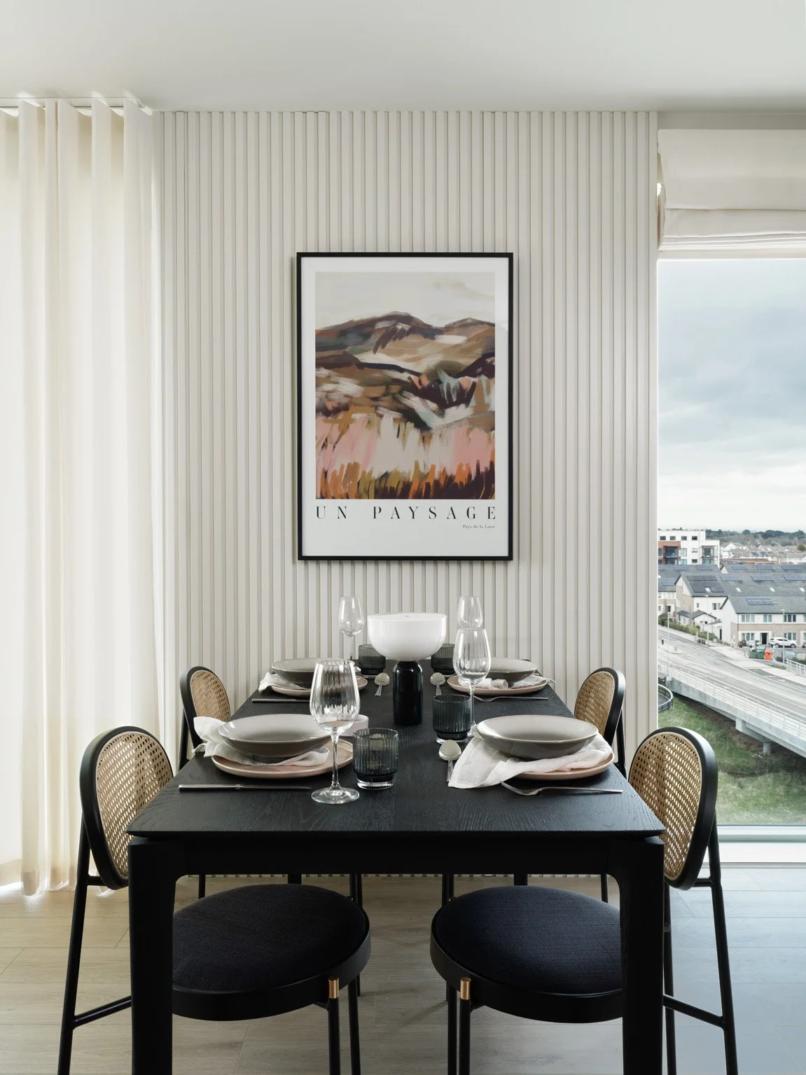 cream dining with blinds open and artwork over table