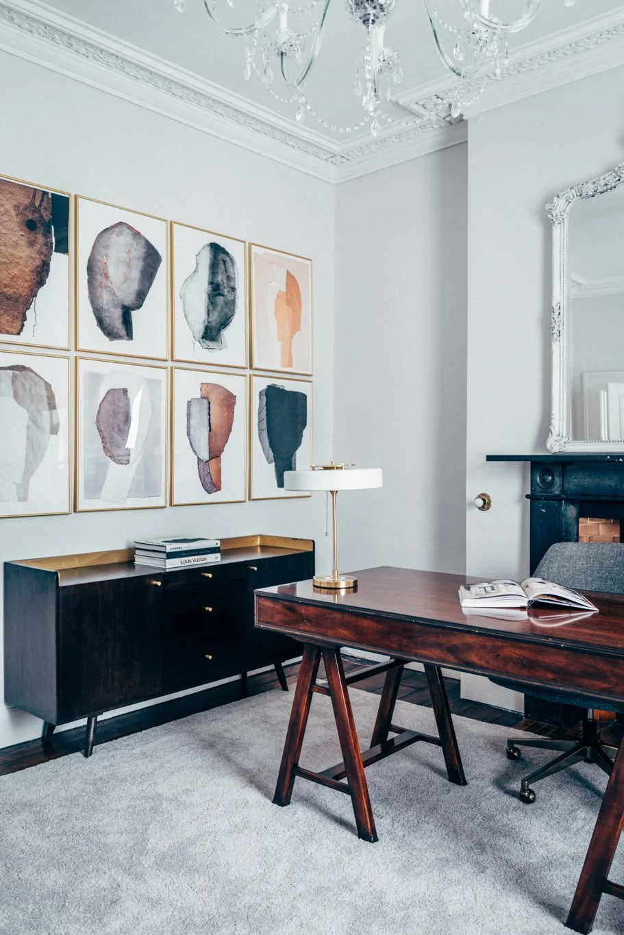 contemporary office space with mahogany desk and wall art