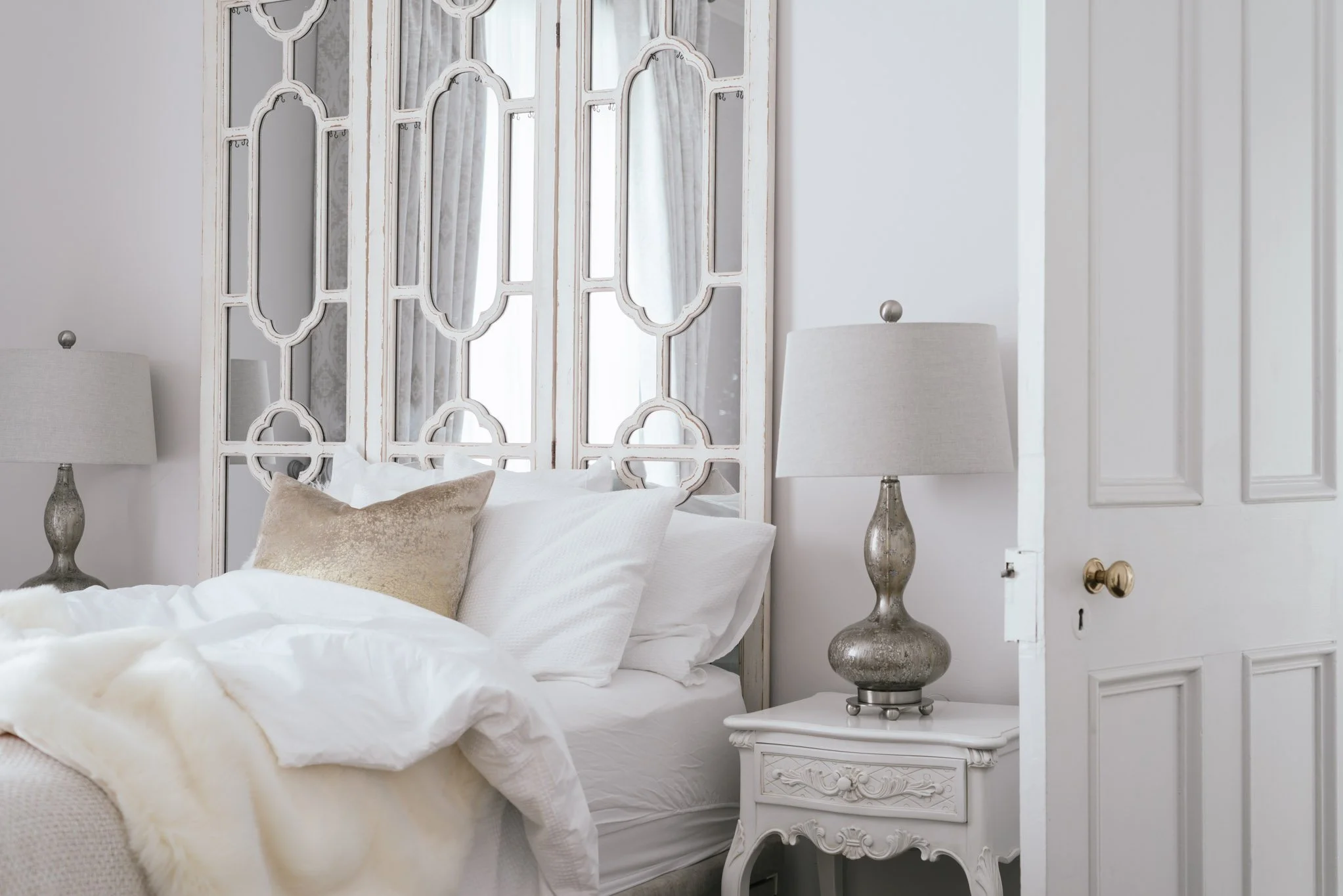 white bedside table with mirrored headboard
