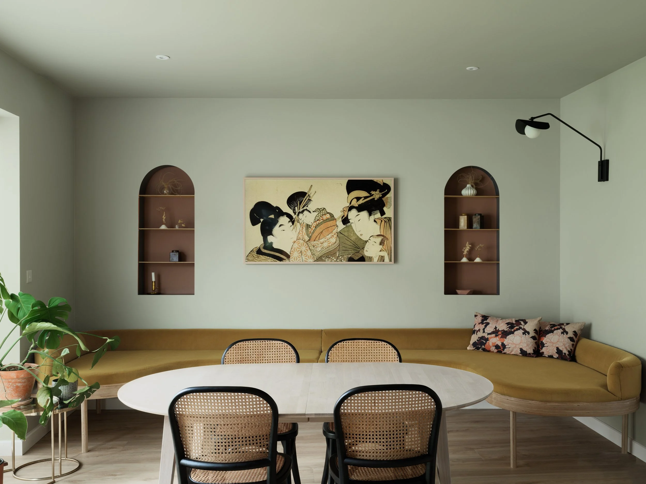 open plan dining area with yellow curved seating and asian artwork on wall