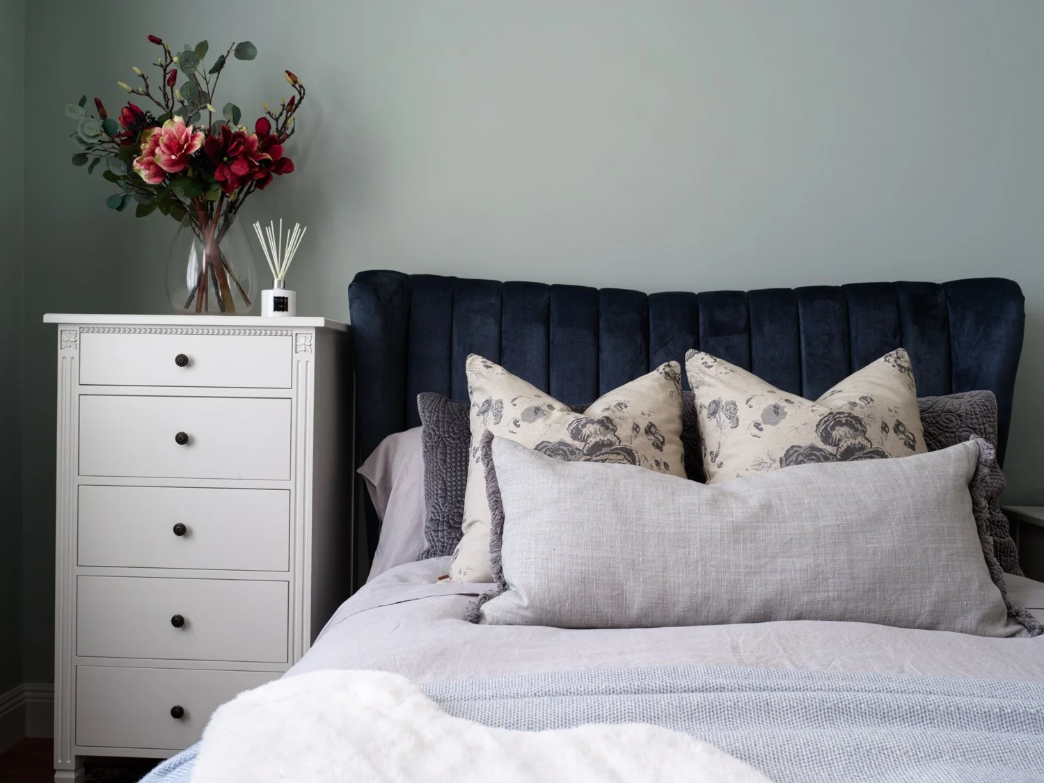 cream bedside drawers and navy headboard