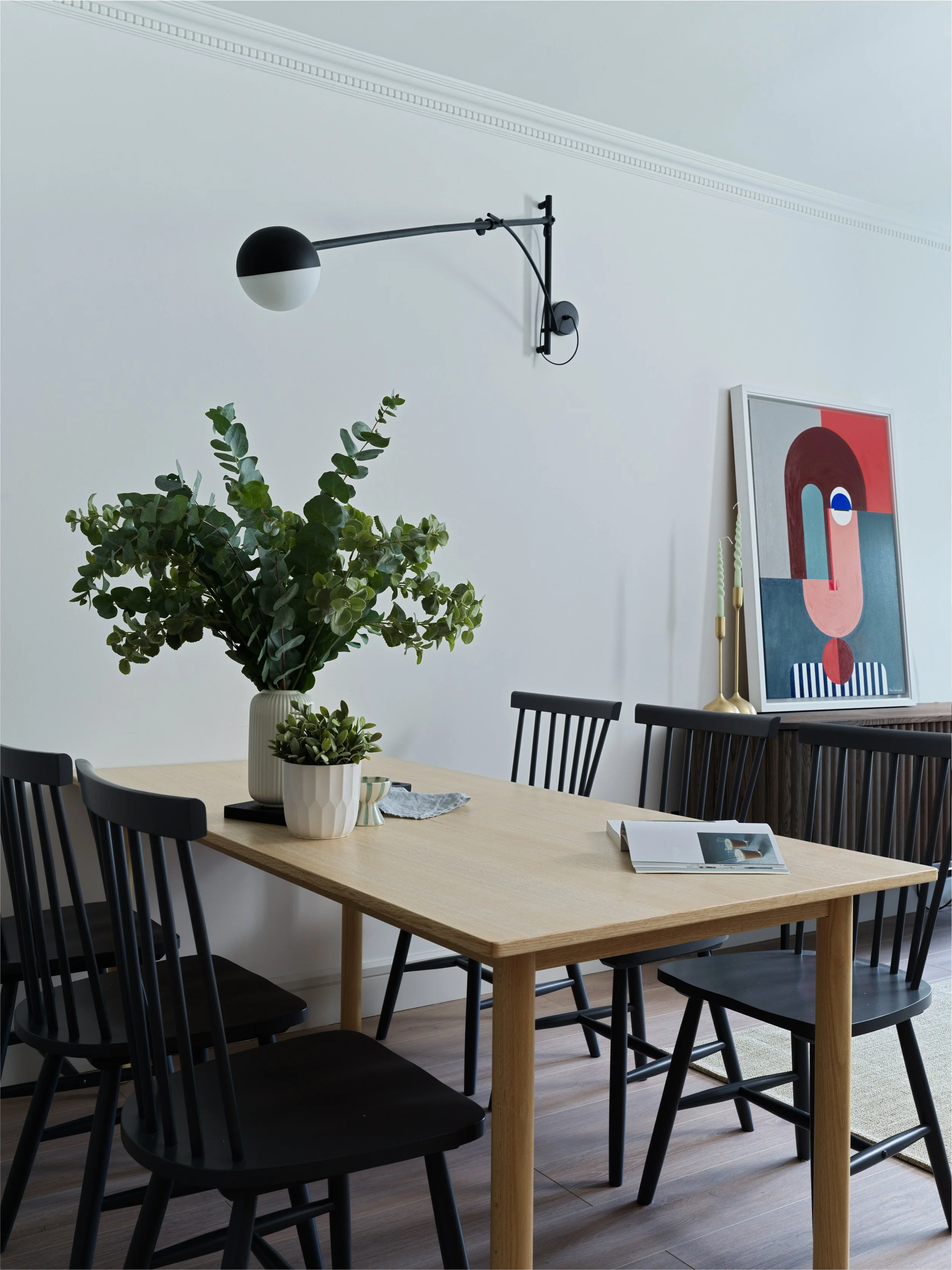 oak dining table with indigo coloured dining chairs and artwork
