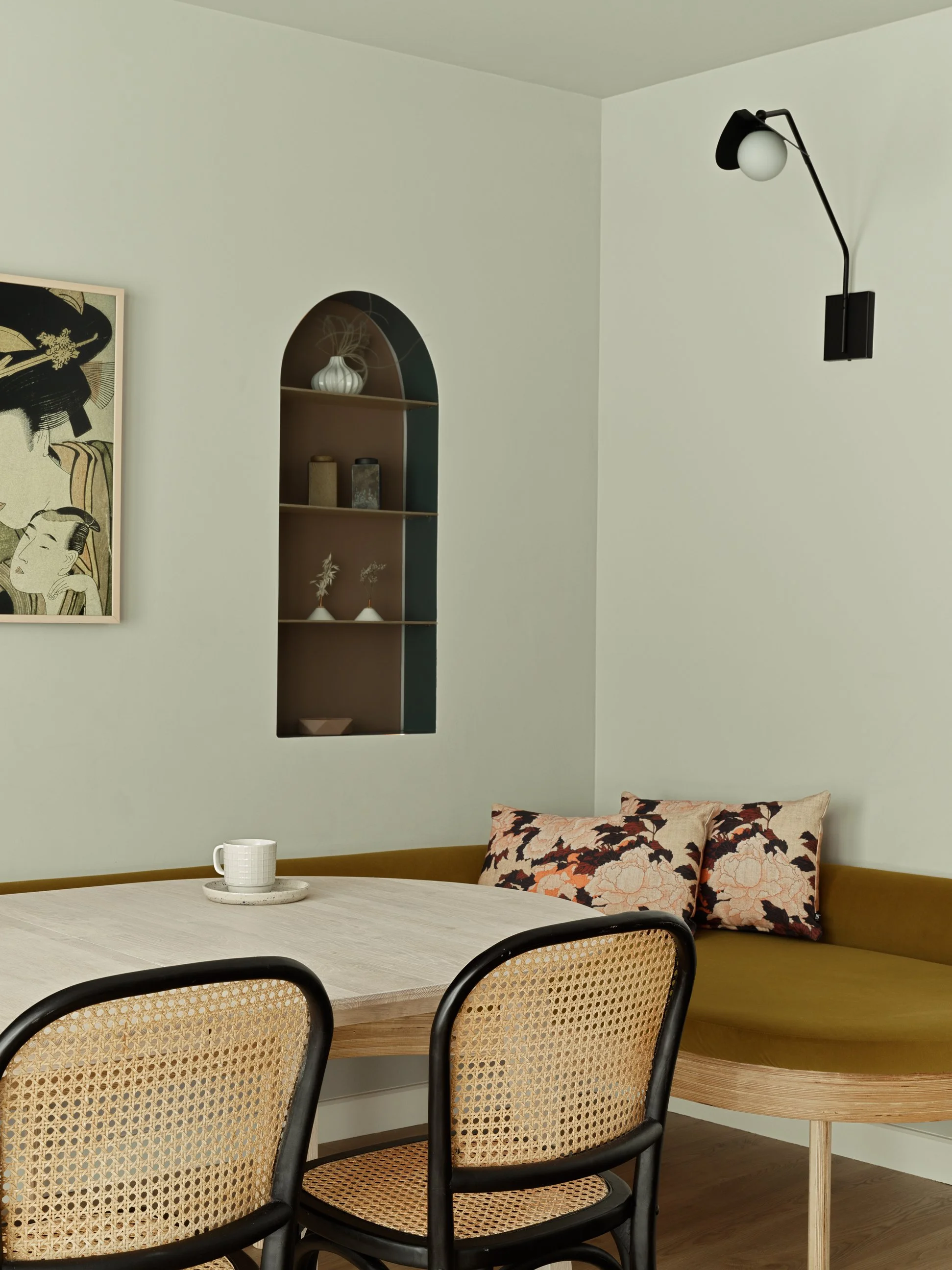 yellow curved seating area with black and rattan dining chairs