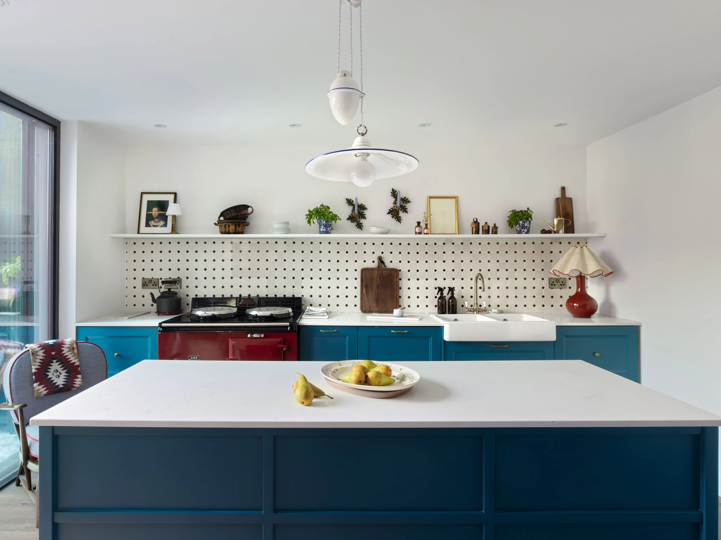 Teal kitchen island with red Stanley range and cream backsplash