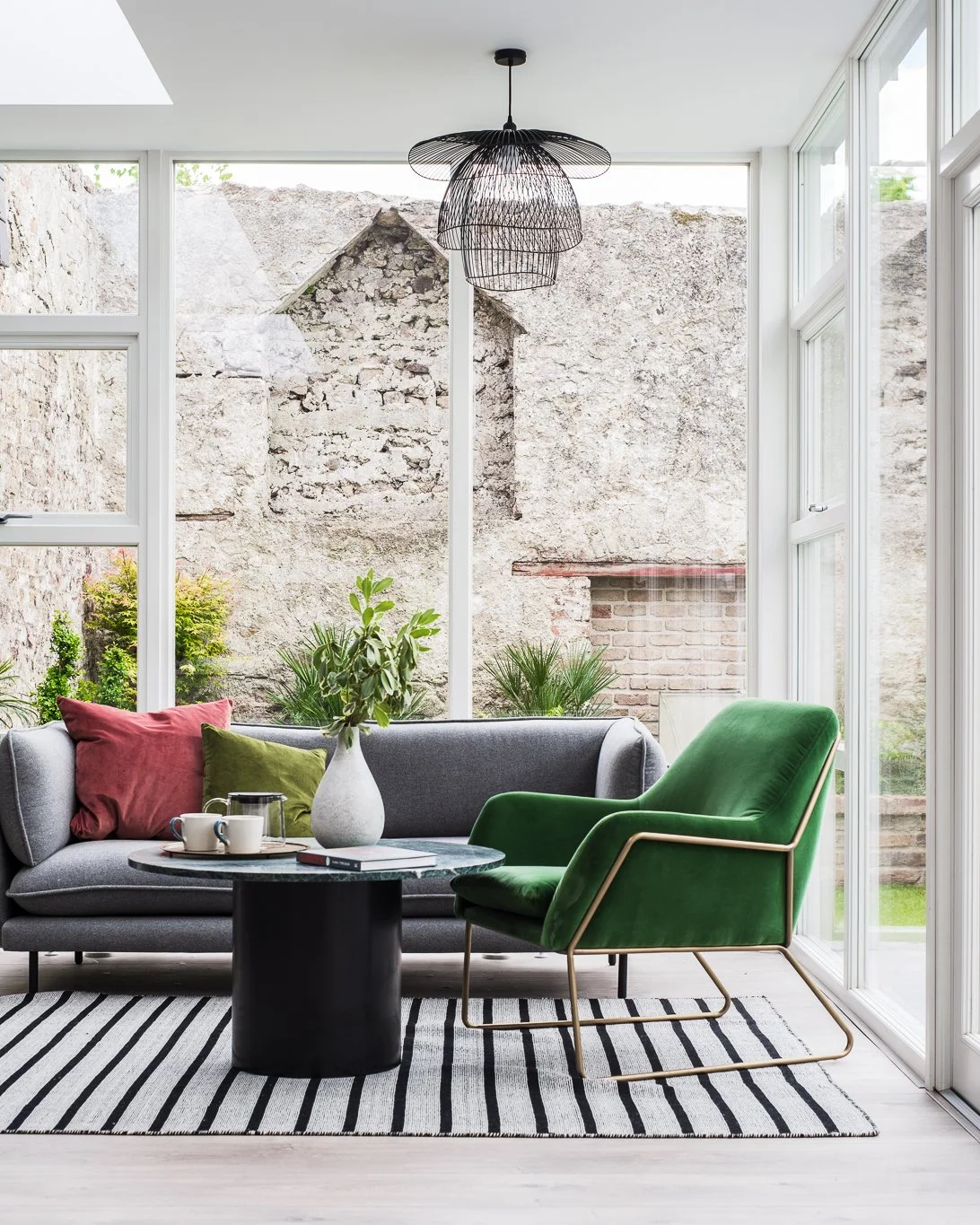 glazed living areas with grey sofa and green armchair