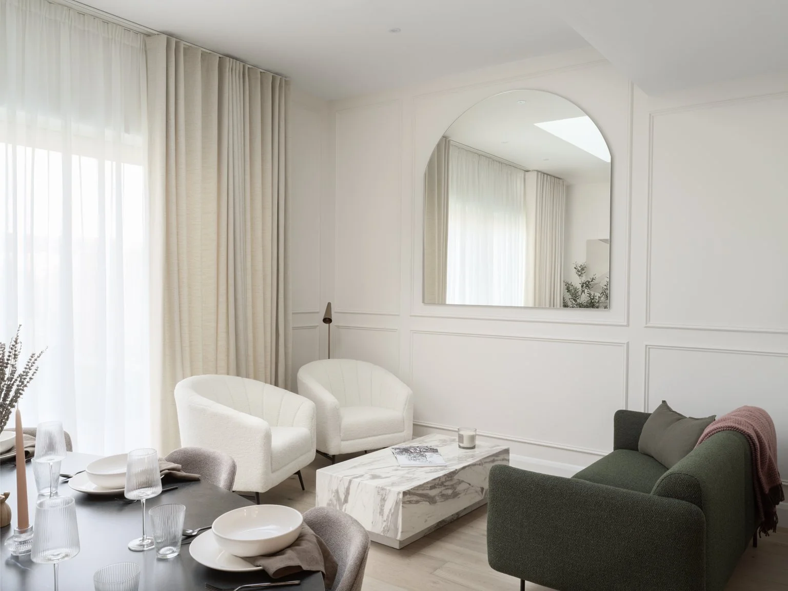 contemporary open plan snug with green sofa and cream arm chairs