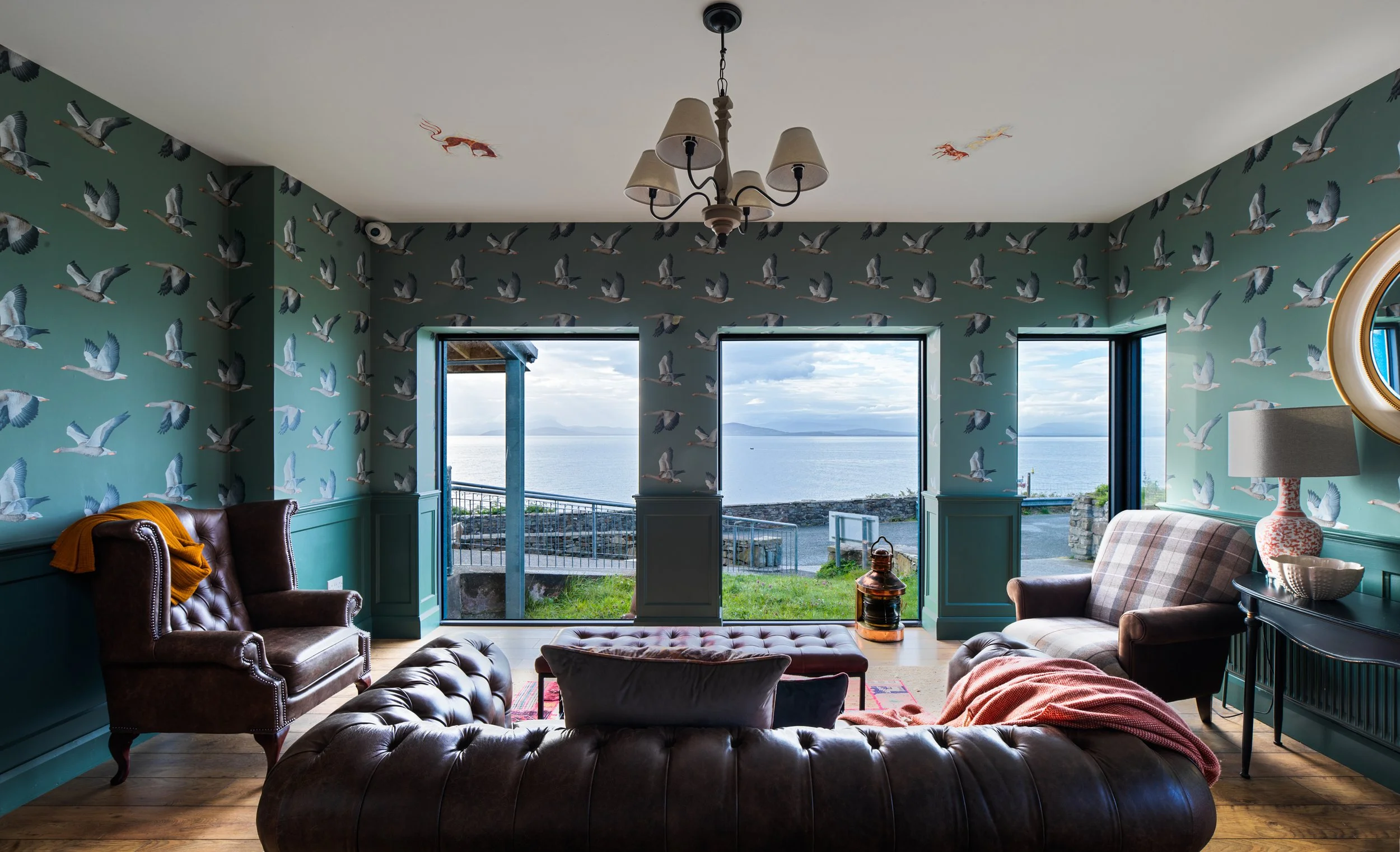 living room space with bird wallpaper and sea views